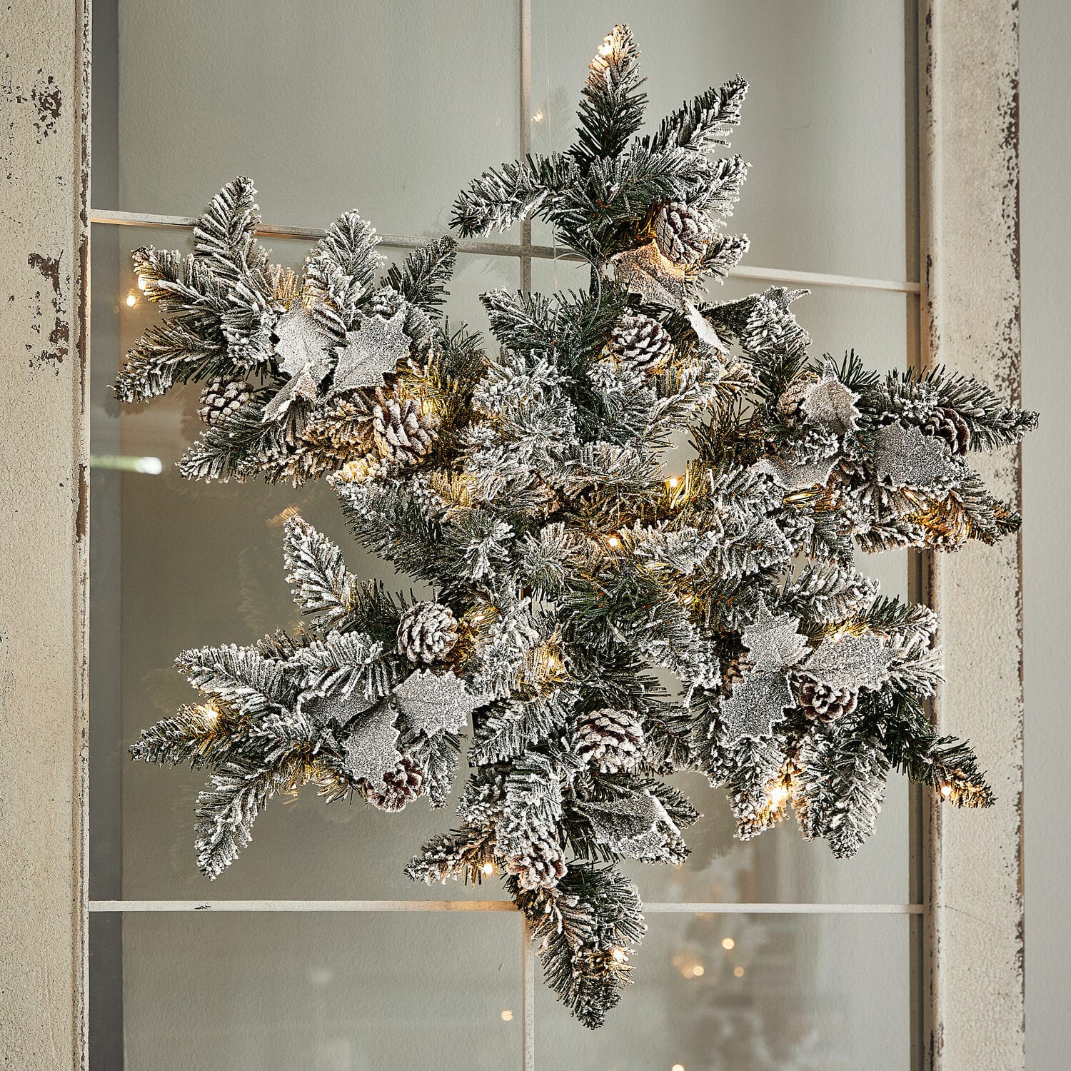 Fiocco di neve con luci a LED Azimara Decorazione natalizia a forma di stella con rami verdi, pigne innevate e luci LED calde