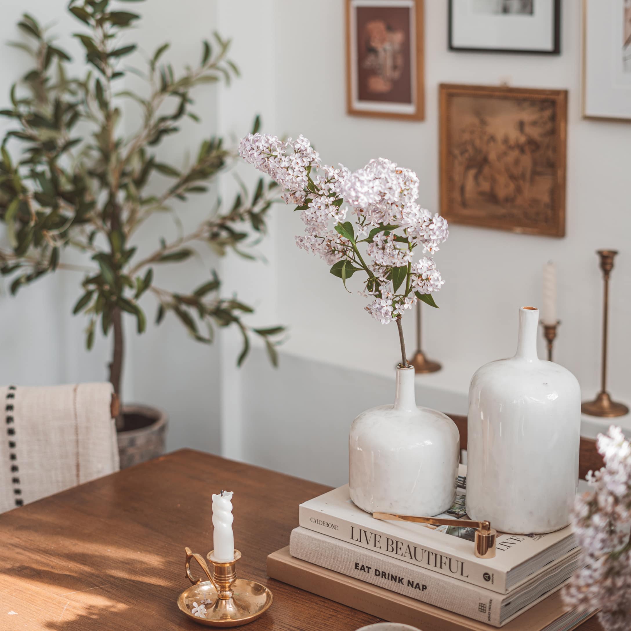 Vasi in ceramica bianca su tavolo in legno con fiori e portacandele dorato vintage