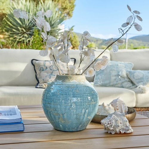 Vaso in ceramica blu su tavolo in legno con decorazioni di piante secche e conchiglie, elegante decorazione d'interni