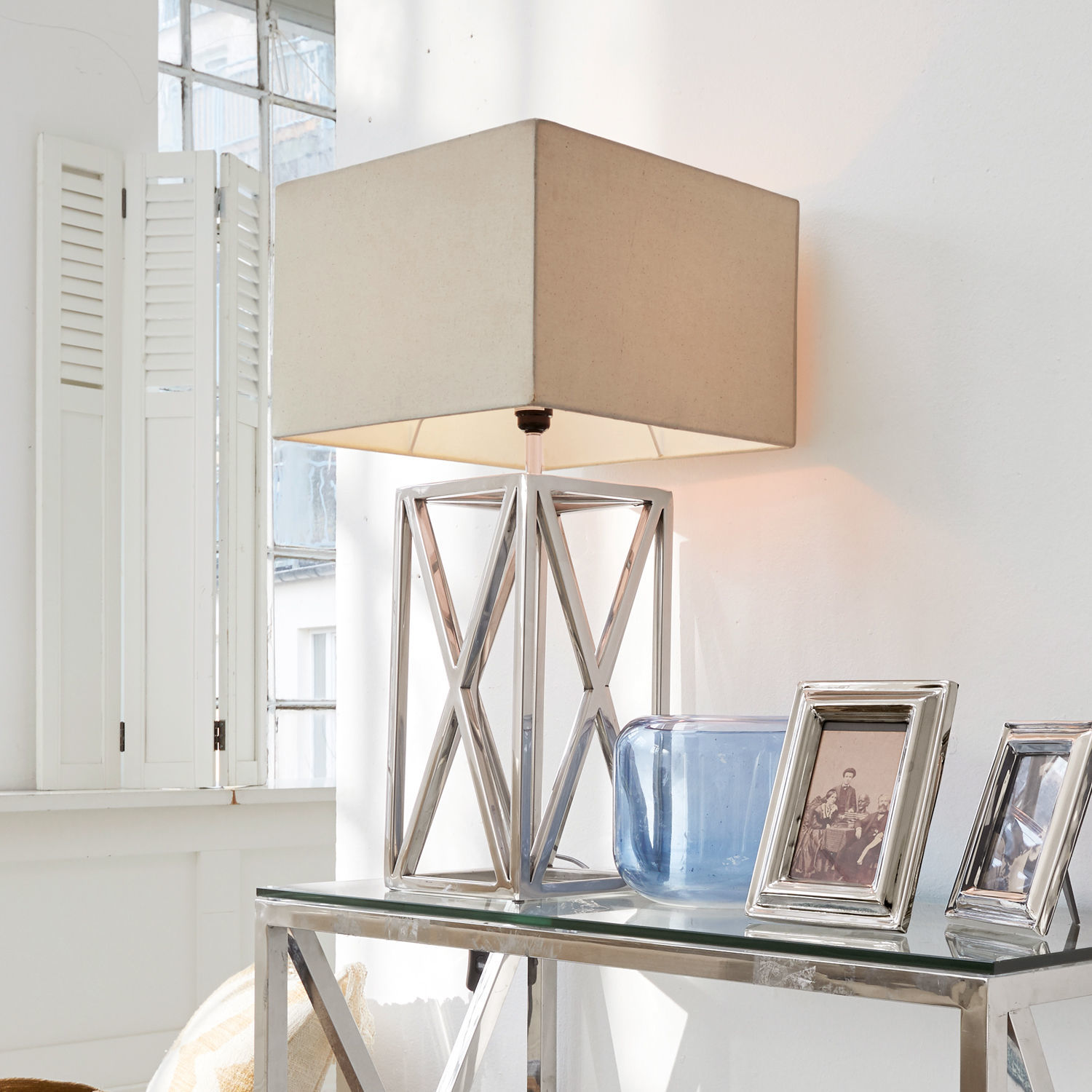 Lampada da tavolo Foix Lampada da tavolo moderna con base in metallo e paralume beige su tavolo in vetro in interno luminoso