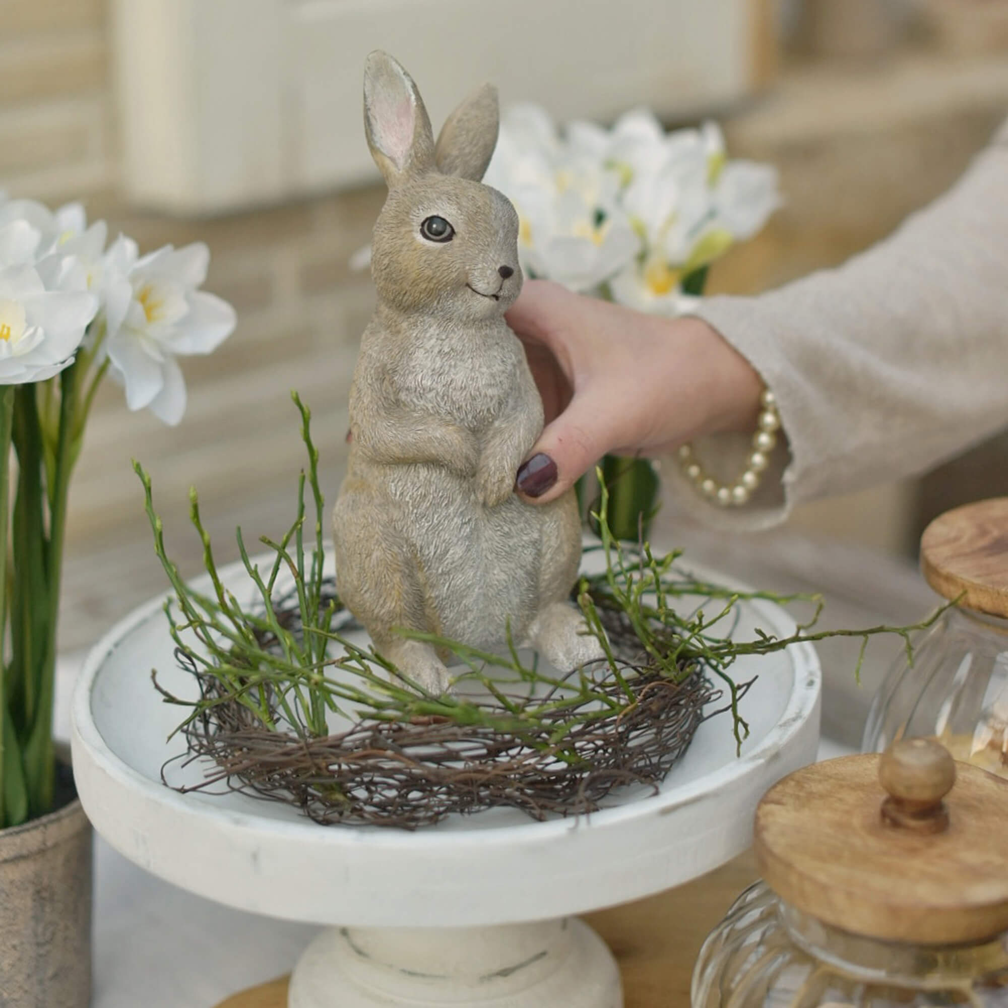 Decorazione coniglio pasquale in colori naturali su base bianca con rami verdi