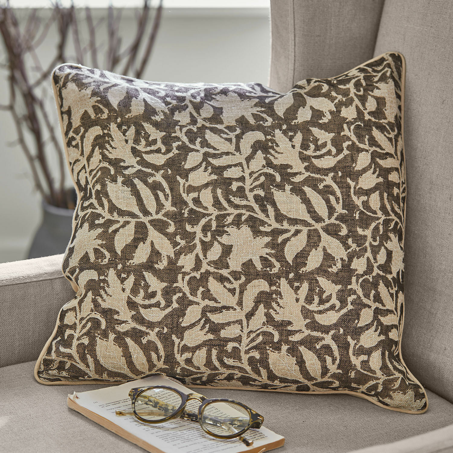 Coppia di copricuscini Ziradayn Cuscino decorativo in cotone marrone e beige con motivo vegetale su divano grigio con occhiali e libro