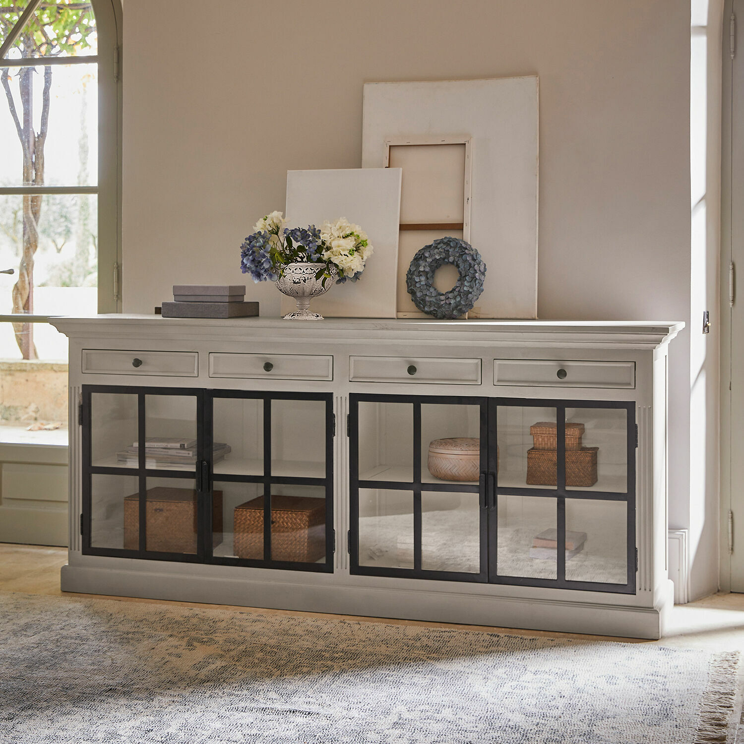 Credenza bassa Pratola Madia in legno bianco con ante in vetro nero e decorazioni sopra in soggiorno