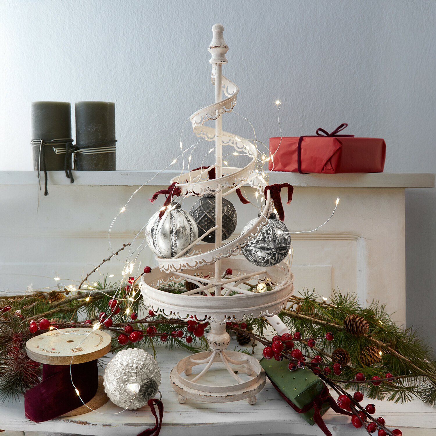 Albero decorativo Gerzat Decorazione natalizia in metallo bianco con palline appese e luci LED, regali rossi e rami verdi sullo sfondo