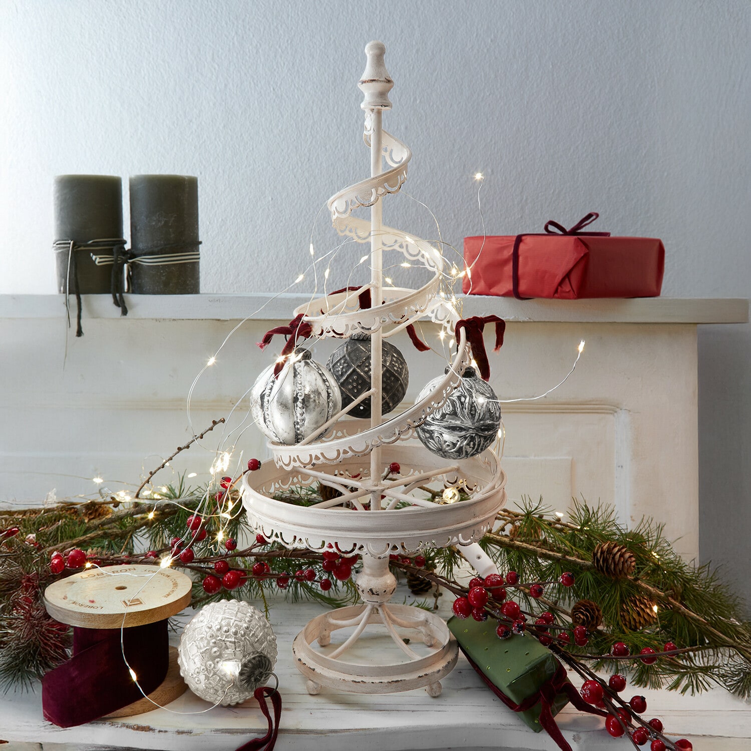 Albero decorativo Gerzat Decorazione natalizia in metallo bianco con palline appese e luci LED, regali rossi e rami verdi sullo sfondo