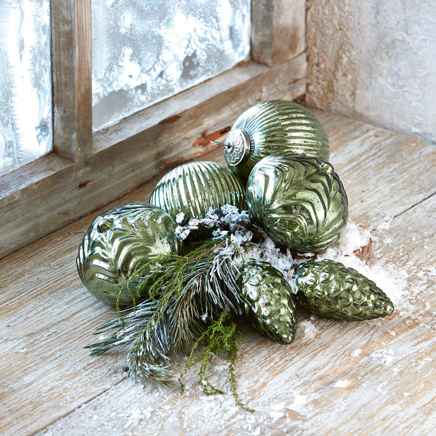 Set di 6 decorazioni natalizie Silverhill Palline di Natale verdi in vetro con diverse texture, rami e neve artificiale su un davanzale in legno