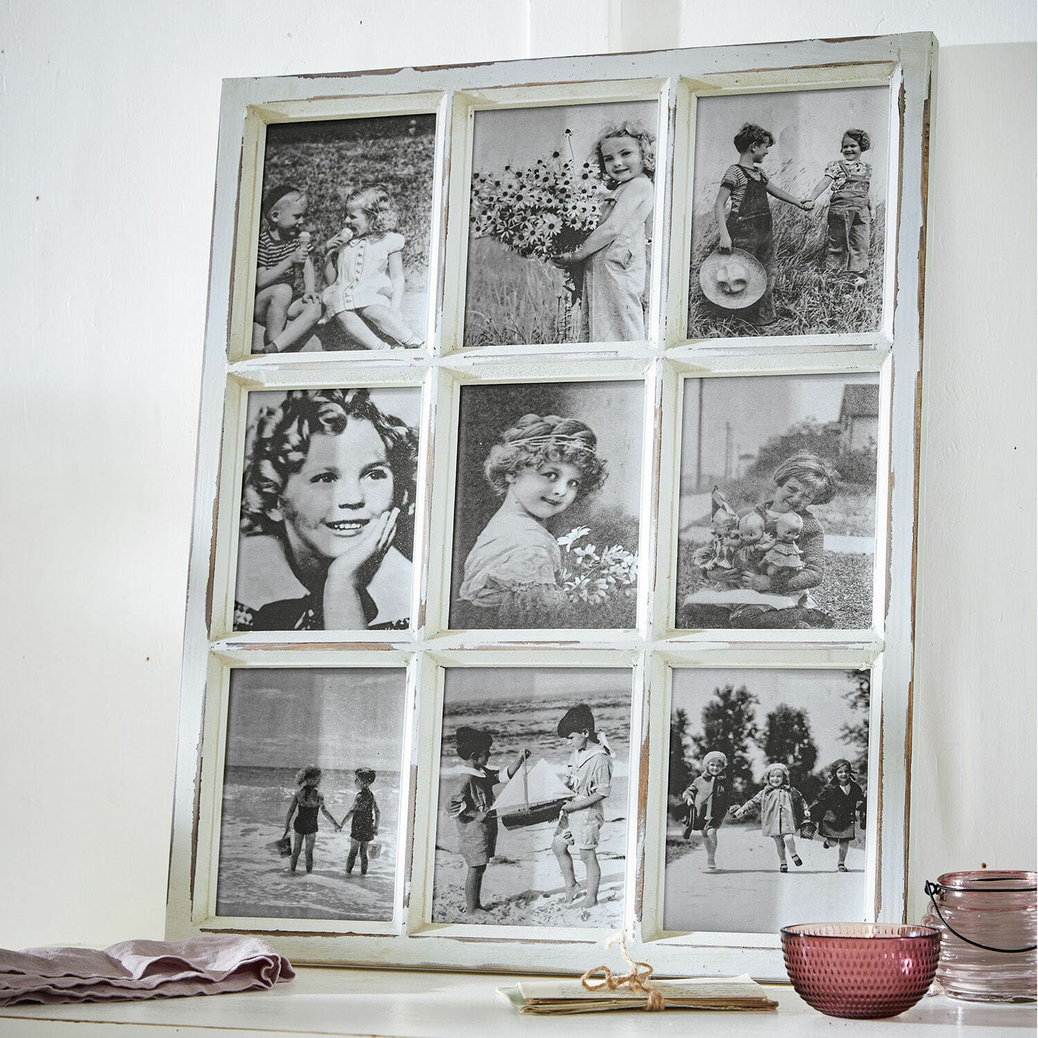 Cornici Vira Cornice in legno bianco con nove foto vintage in bianco e nero di bambini su un tavolo