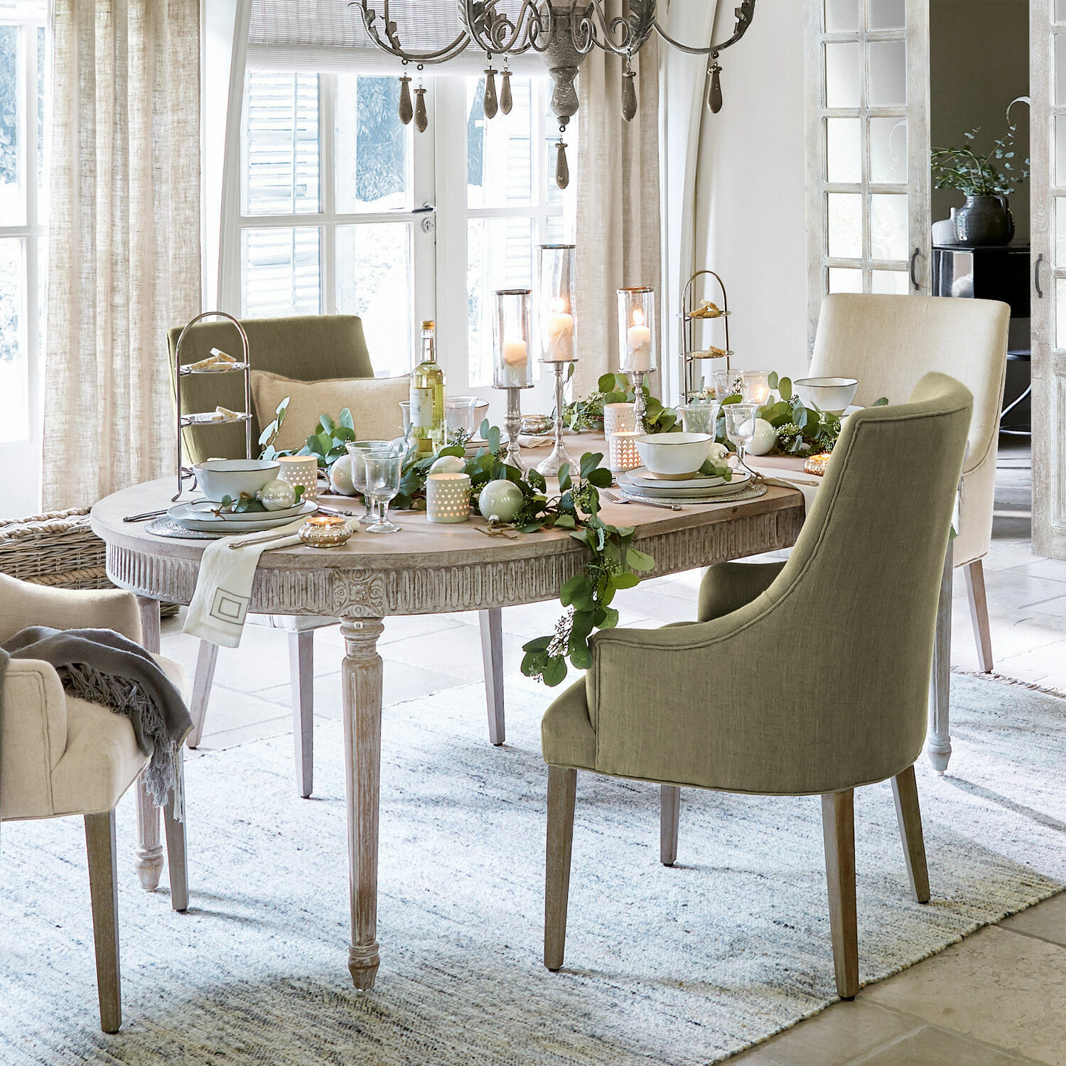 Tavolo Cienegas Sala da pranzo con tavolo ovale in legno e sedie imbottite verdi e beige, decorazioni festive
