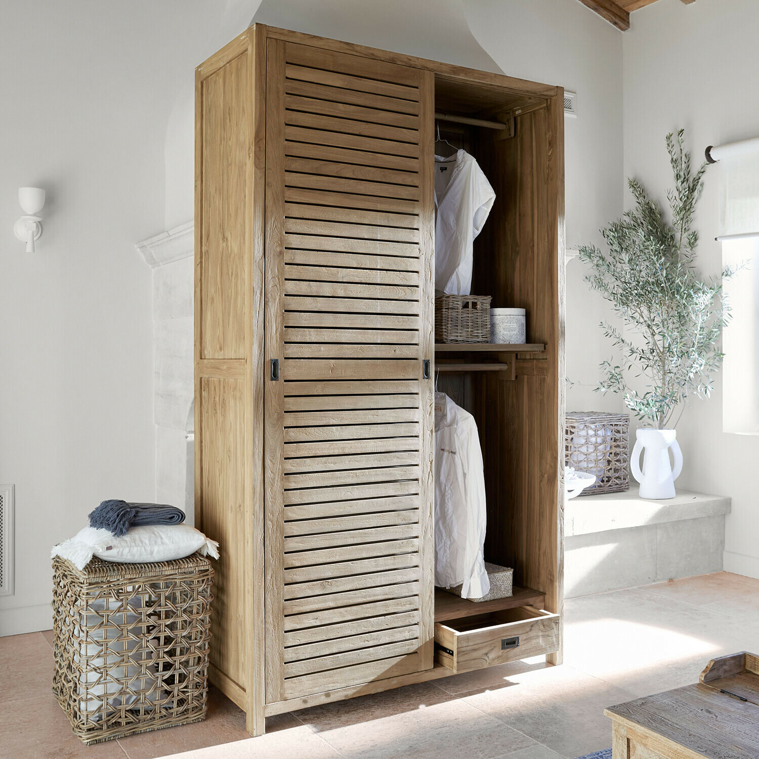 Armadio in legno chiaro con ante scorrevoli e cassetto in ambiente luminoso e moderno