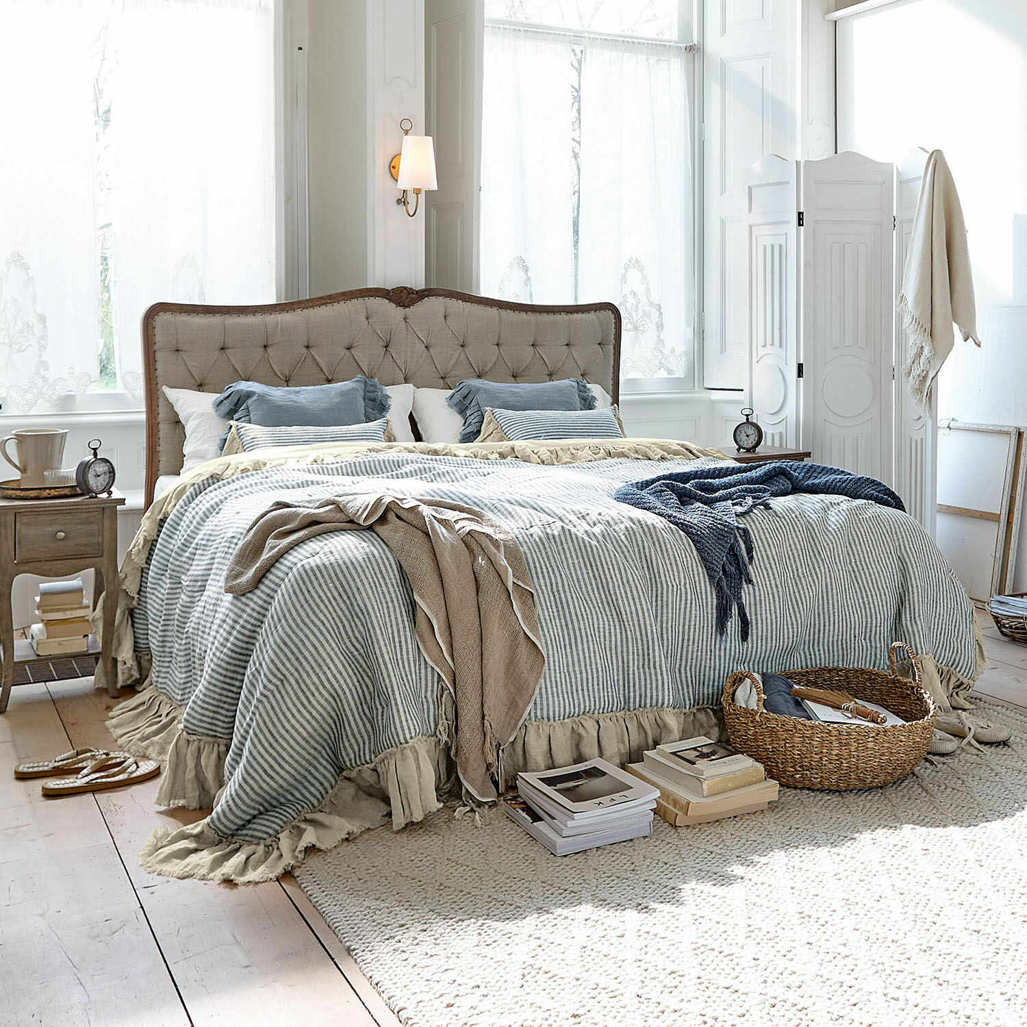 Trapunta Alexane Camera accogliente con letto in tessuto beige e biancheria da letto a righe blu e bianco