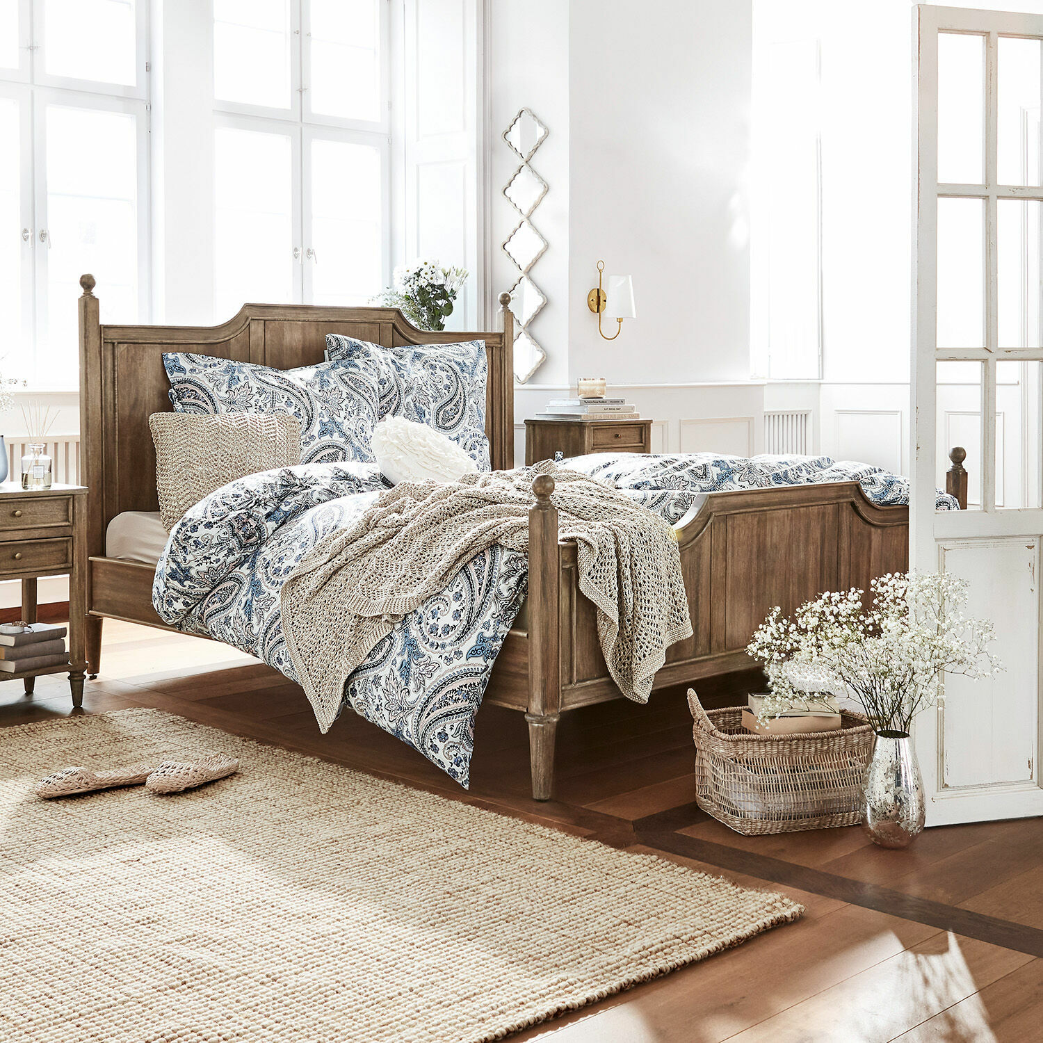 Letto Lubbock Camera da letto con letto in legno e biancheria da letto blu-bianca a motivo paisley, tappeto naturale e decorazioni