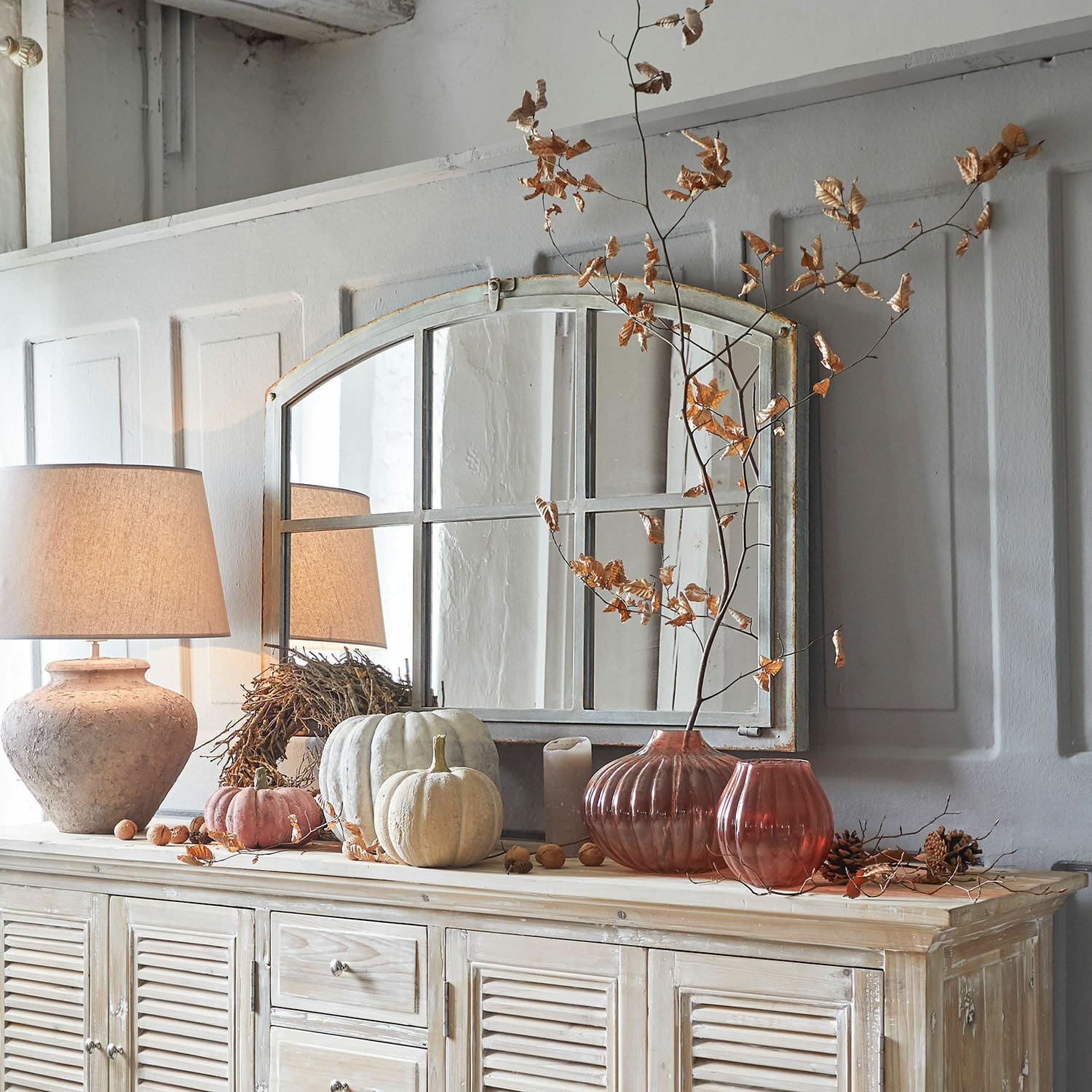 Mobile decorativo con specchio, lampada e decorazioni autunnali in colori naturali per soggiorno