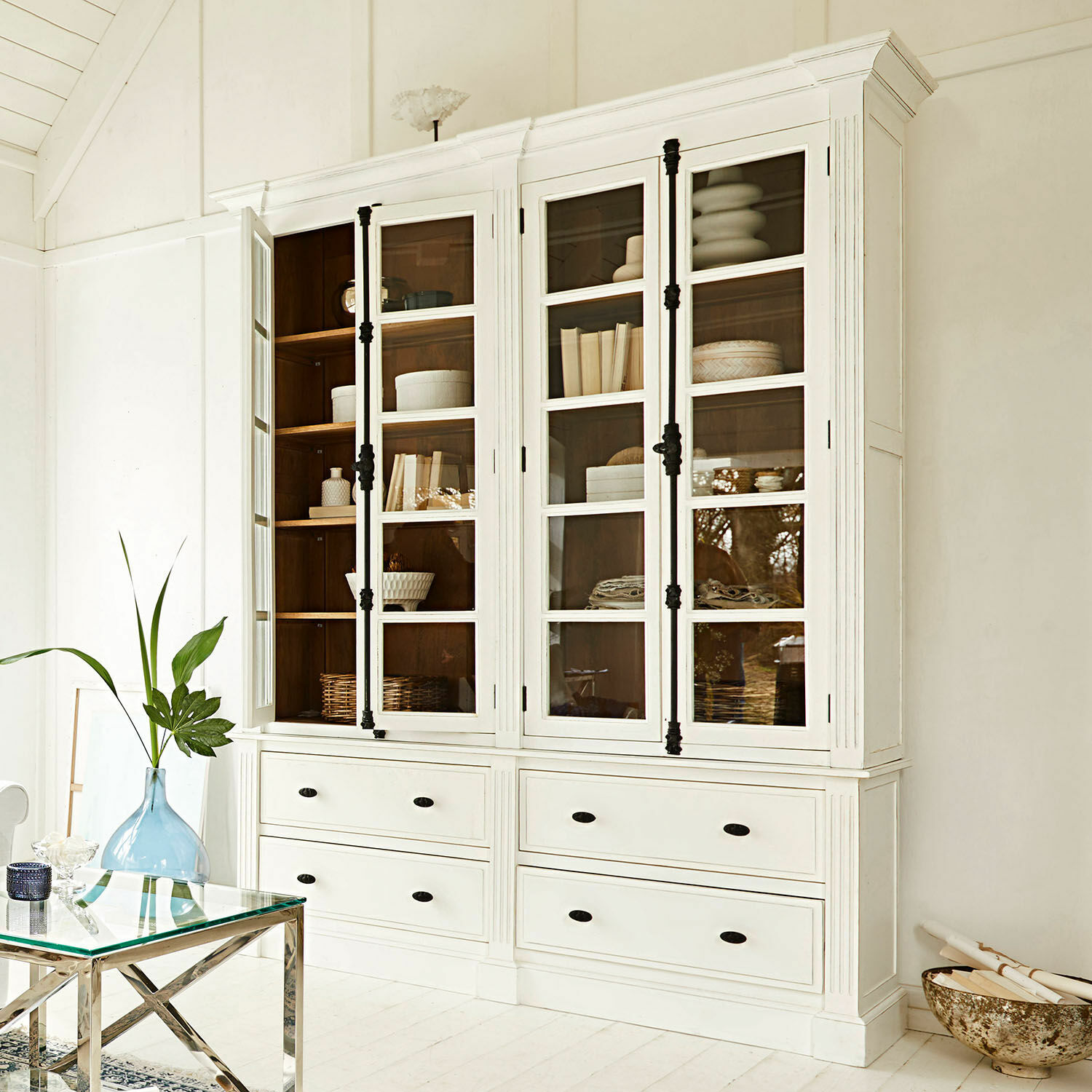 Libreria Laimont Vetrina in legno bianco con ante in vetro e maniglie nere in interno luminoso