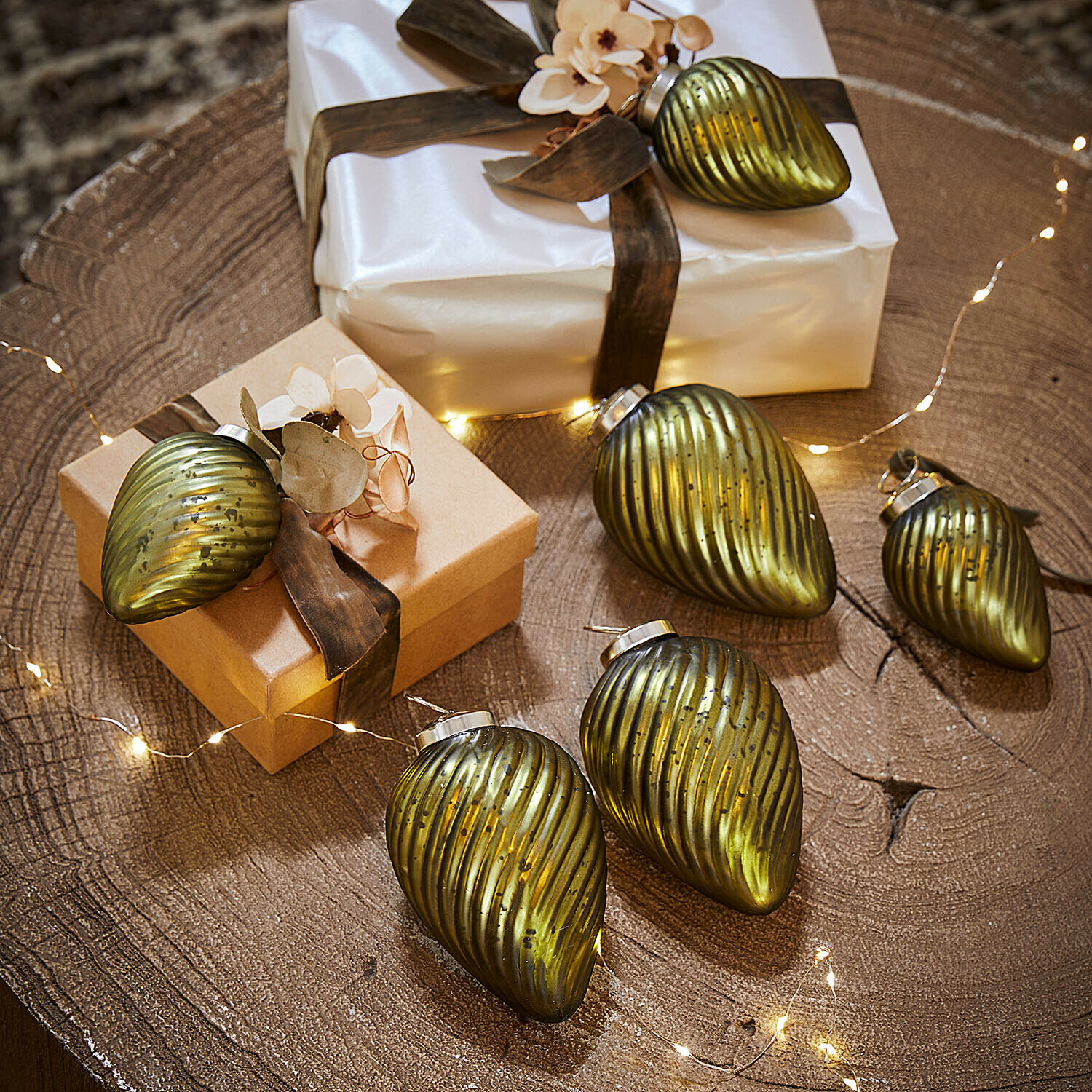 Set di 6 decorazioni natalizie Salema Set di decorazioni natalizie in vetro verde su tavolo di legno con regali e luci LED