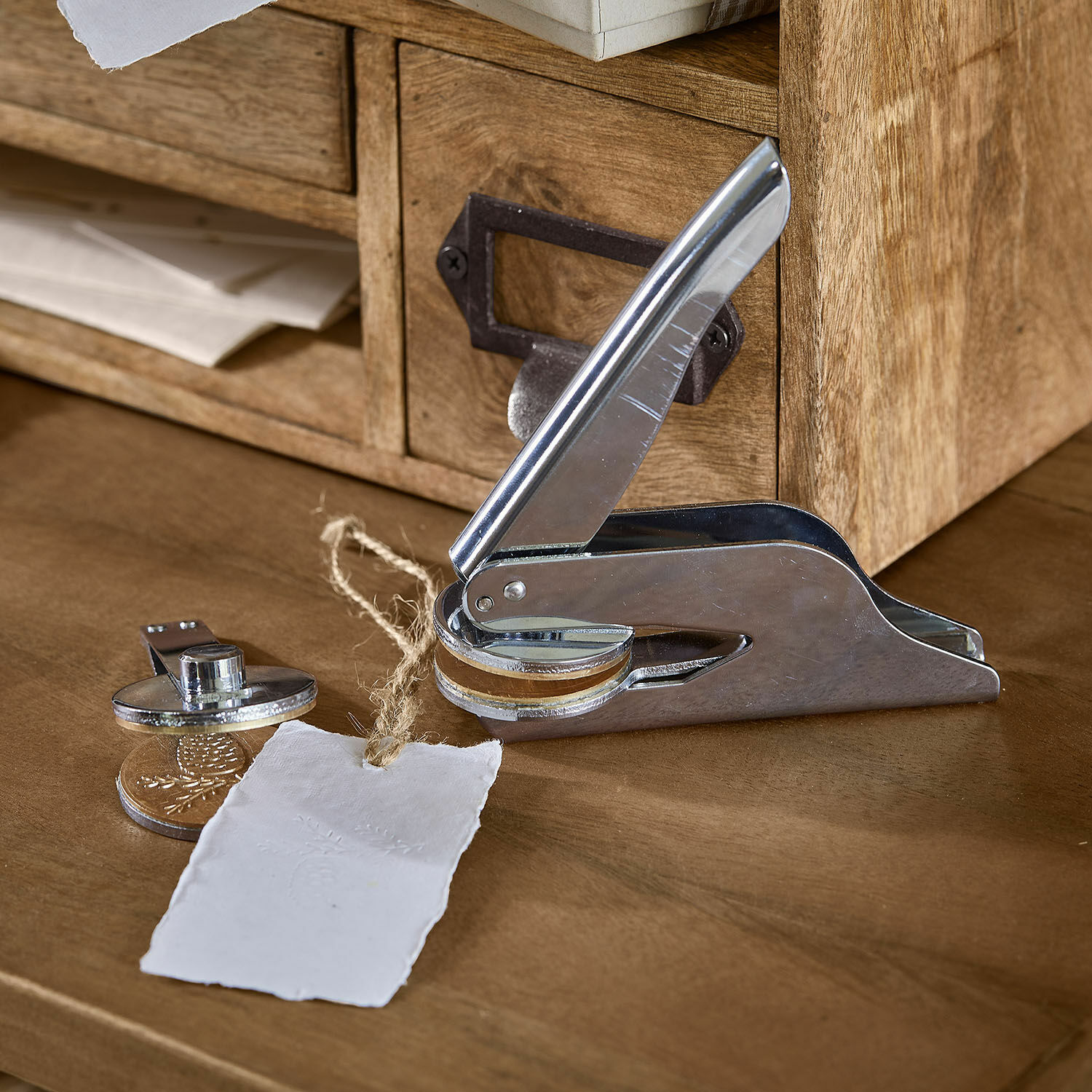 Timbro a rilievo Prenisto Pressa in metallo per carta con elemento in legno su scrivania in legno con etichetta di carta
