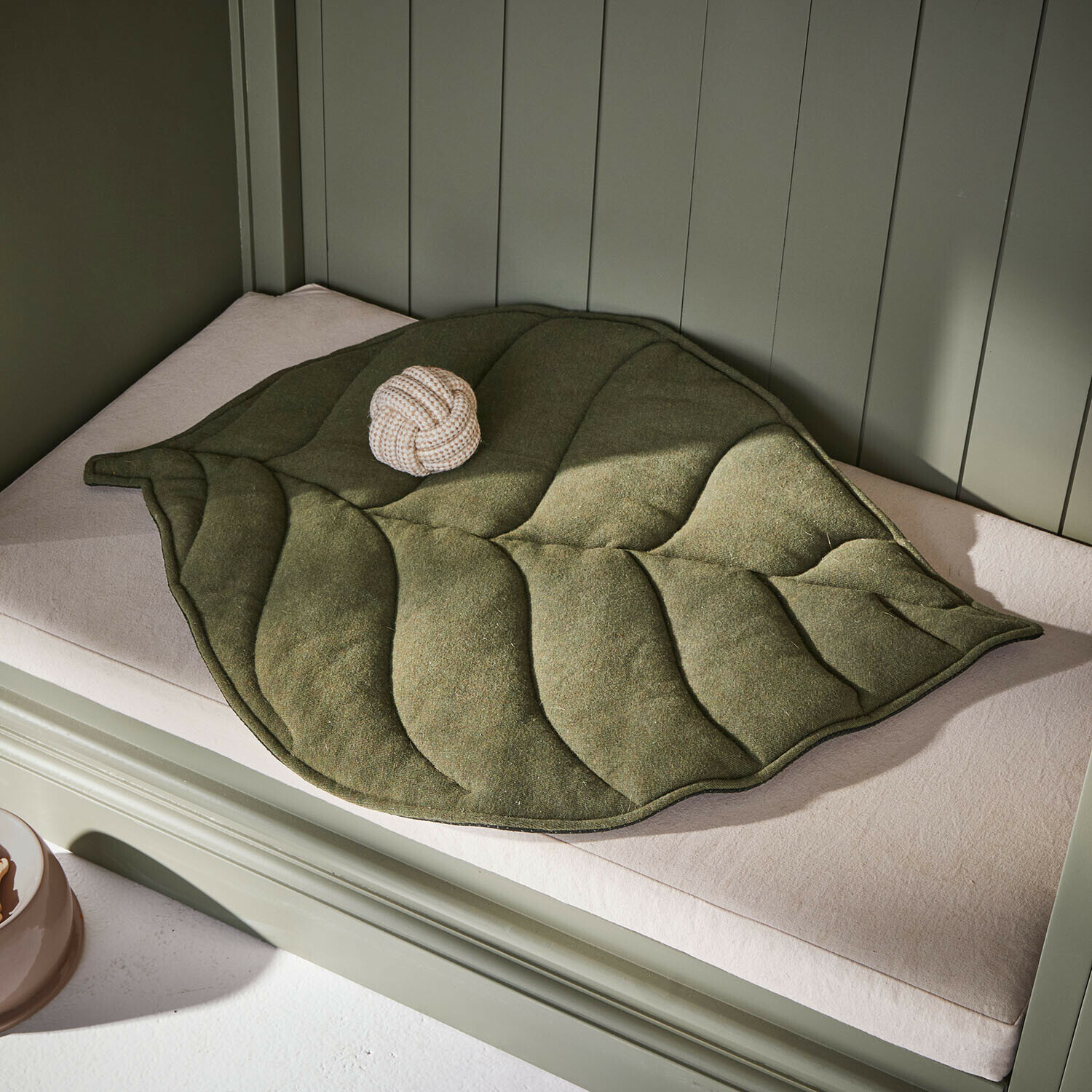 Tappetino per animali Keirena Tappetino verde a forma di foglia in materiale morbido su cuscino chiaro, decorativo e confortevole