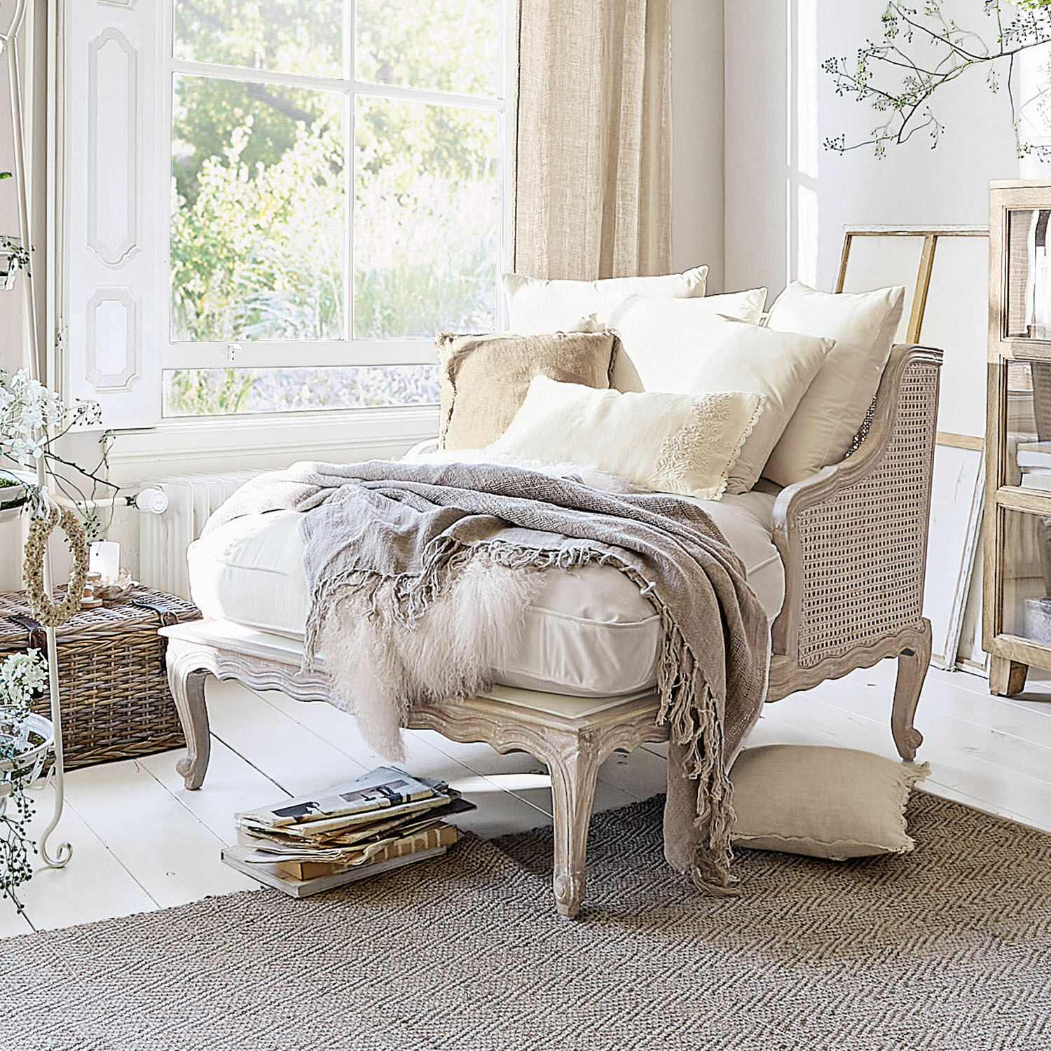 Chaise longue Dronne Divano beige in legno e rattan con cuscini crema e coperta morbida in interno luminoso