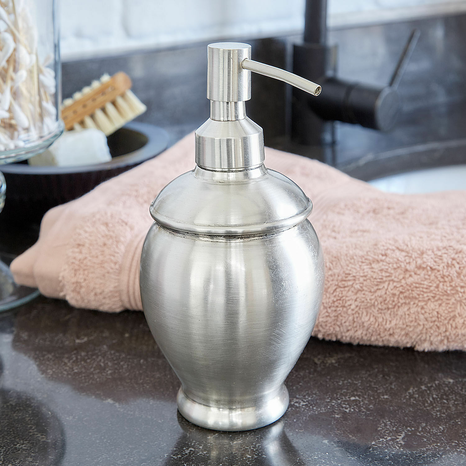 Dispenser per sapone Alintra Dispenser di sapone in metallo argento su lavabo con asciugamano rosa sullo sfondo