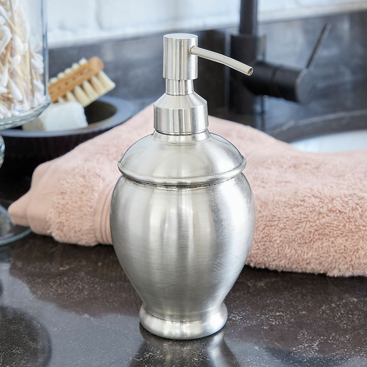 Dispenser per sapone Alintra Dispenser di sapone in metallo argento su lavabo con asciugamano rosa sullo sfondo