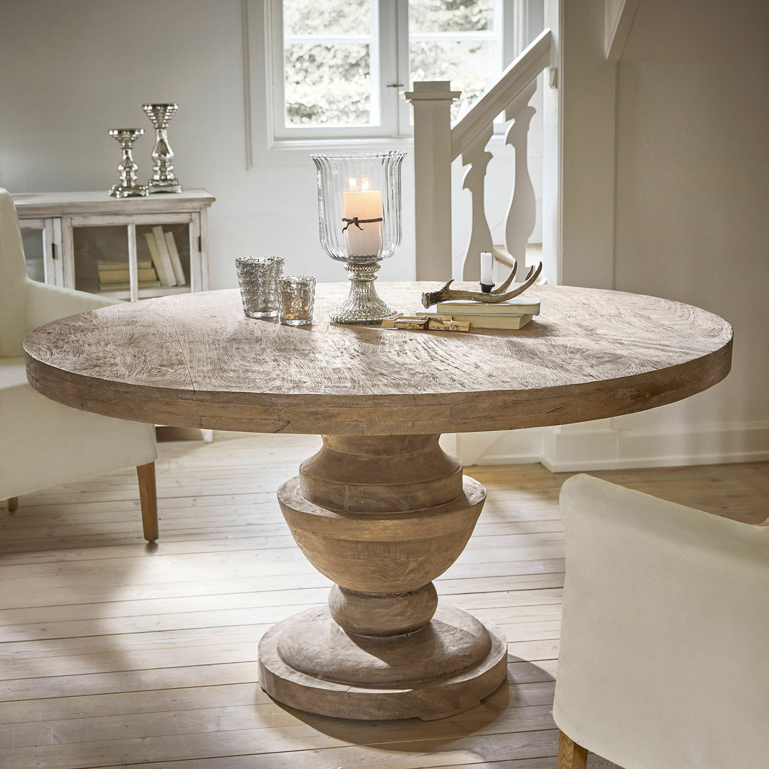 Tavolo Retonfey Tavolo rotondo in legno di mango colore naturale con candelabri decorativi e libri sul piano