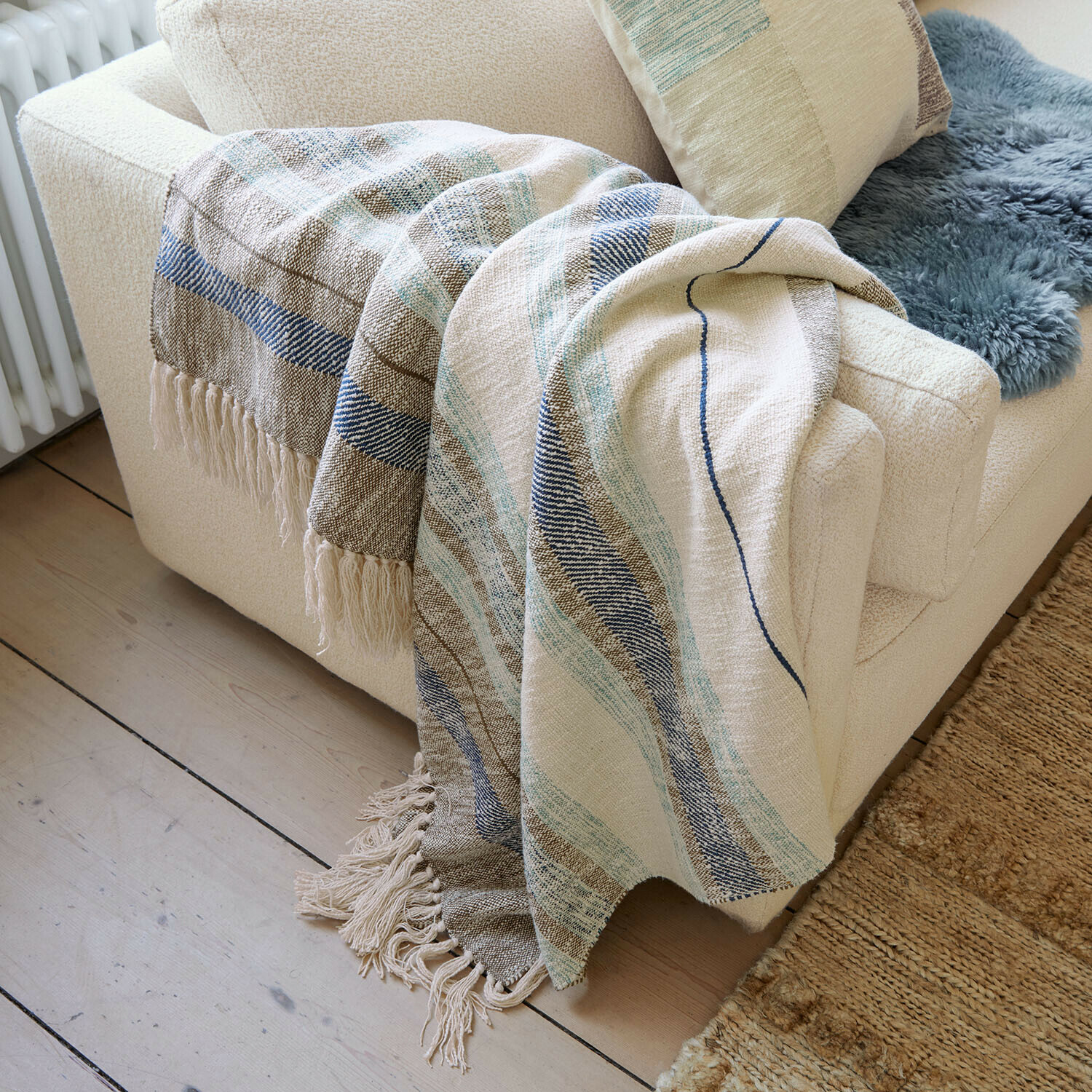 Plaid Maresas Coperta morbida in cotone beige con righe blu e frange su divano crema in soggiorno