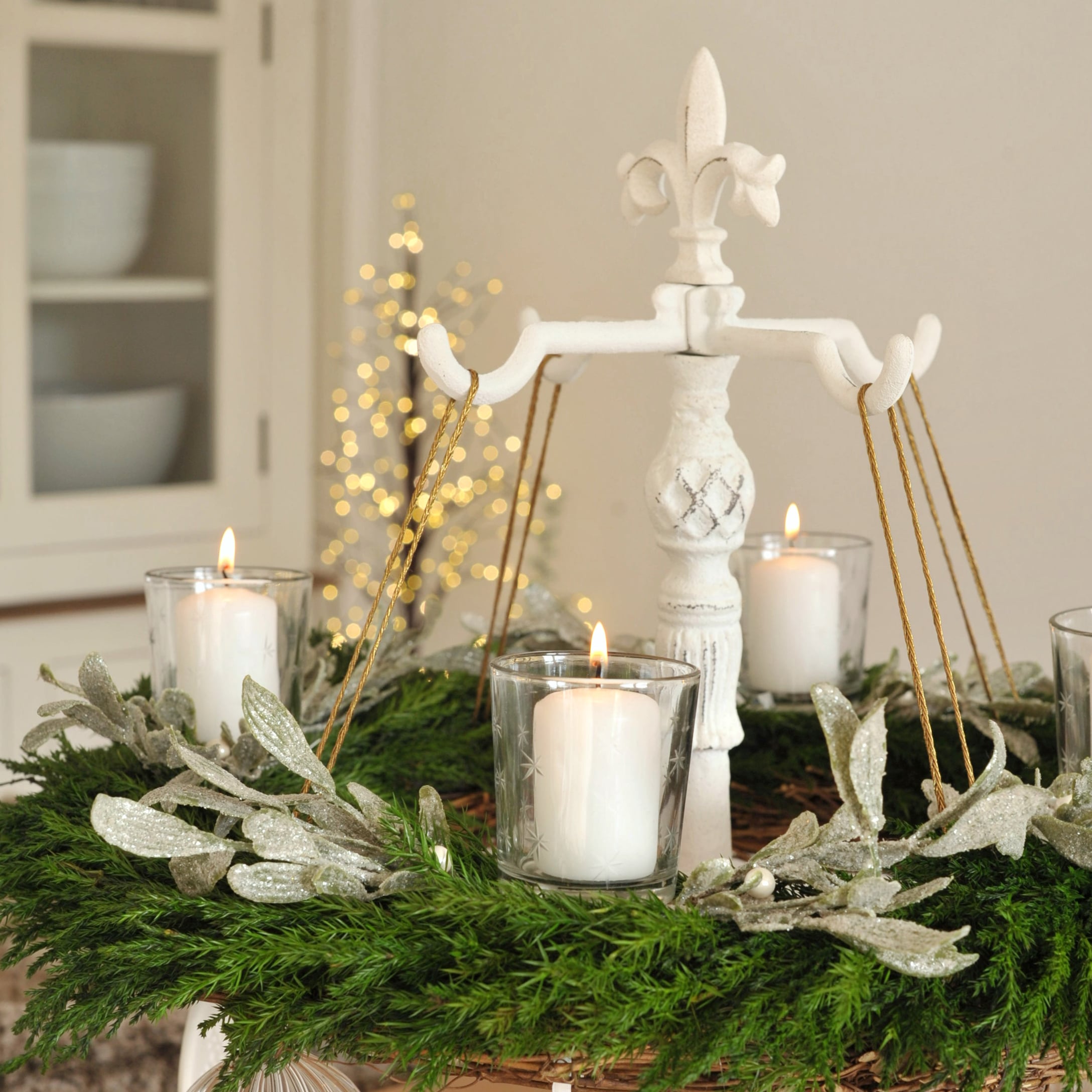 Supporto in metallo bianco con quattro candele e corona verde per decorazione natalizia d'Avvento