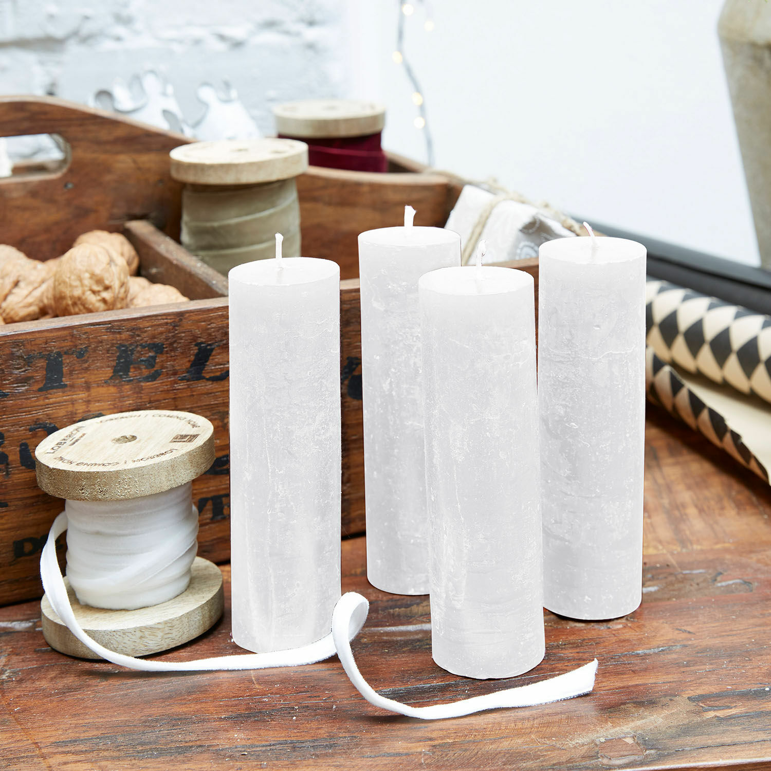 Set di 4 candele Muriel Set di quattro candele bianche in cera naturale su tavolo di legno con decorazioni