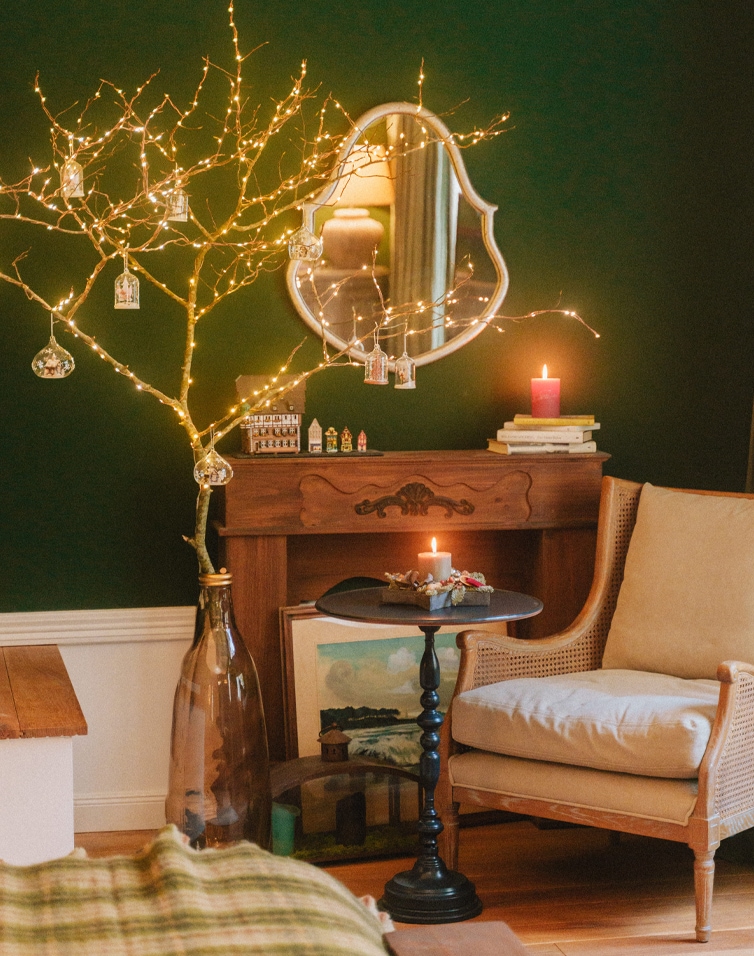 Soggiorno accogliente con poltrona beige, tavolino nero e albero decorativo con luci LED