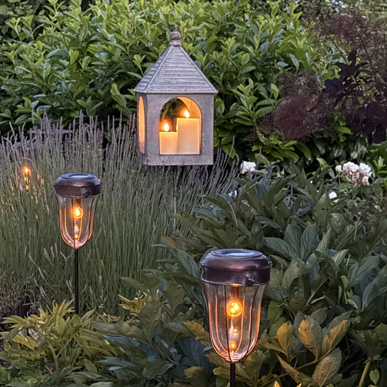 Giardino con luci solari e lanterna sospesa con candele decorative, illuminazione esterna