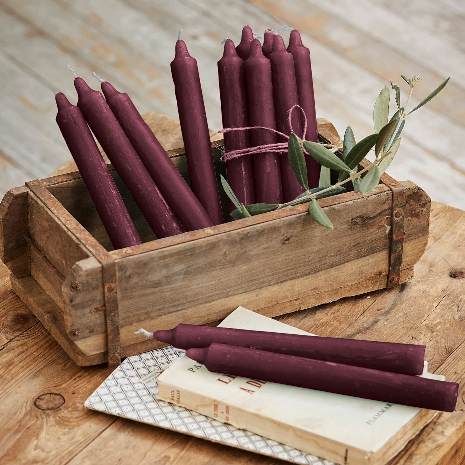 Set di 12 candele Bauceau Set di candele bordeaux in cera in scatola di legno su tavolo rustico
