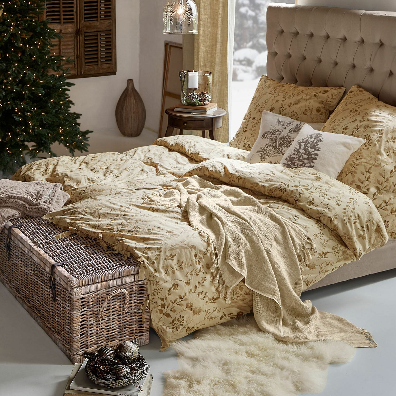 Biancheria da letto Maraviglio Biancheria da letto beige con motivo floreale su letto con testiera imbottita in ambiente accogliente