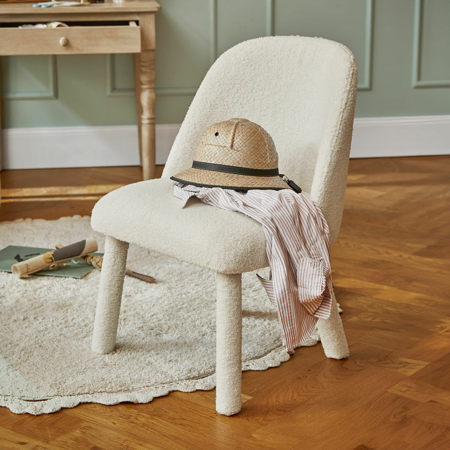Sedia per bambini Ivrielle Sedia imbottita in tessuto bianco con cappello di paglia e camicia a righe su pavimento in legno