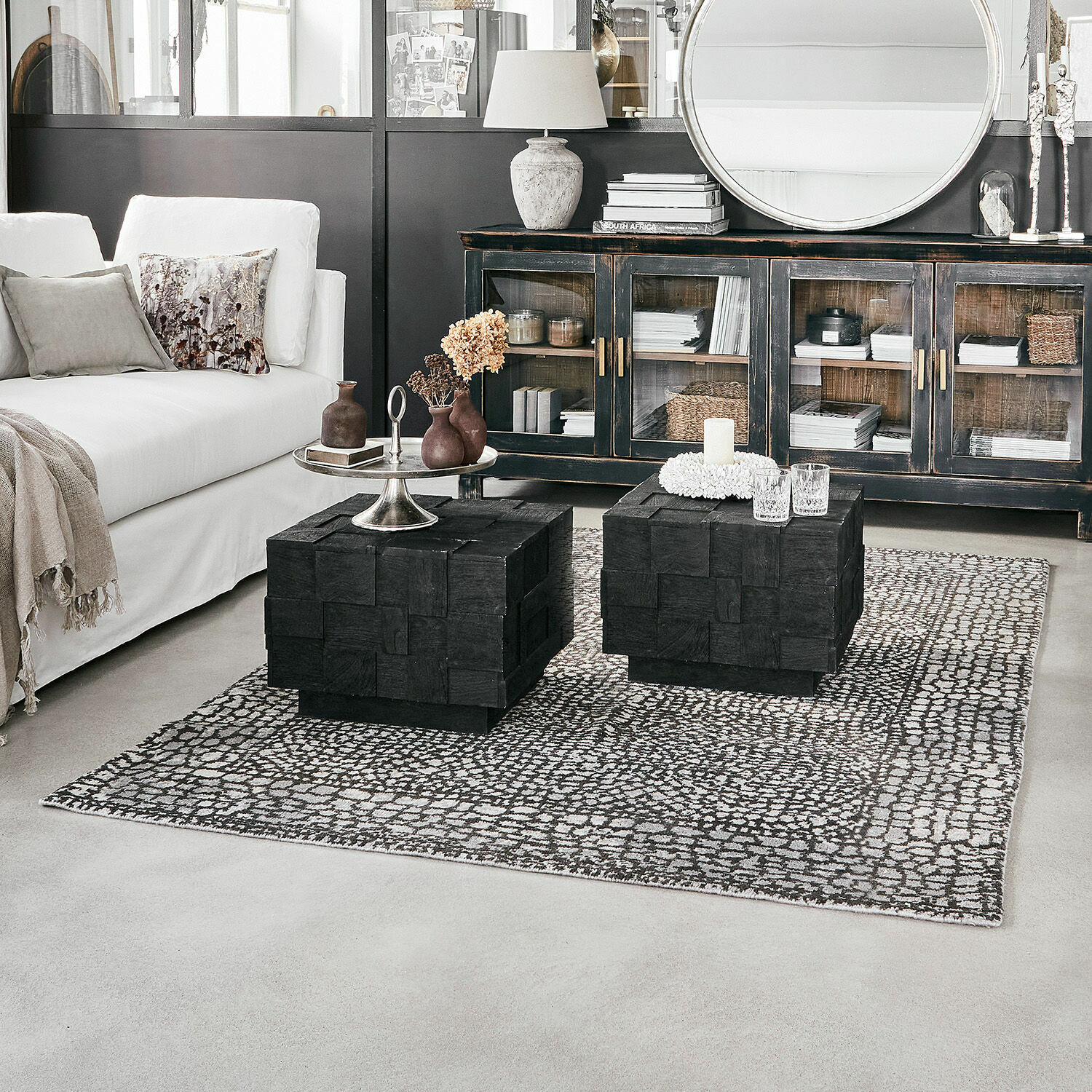 Tappeto Vermont Soggiorno moderno con divano bianco, tavolini in legno nero e credenza con ante in vetro