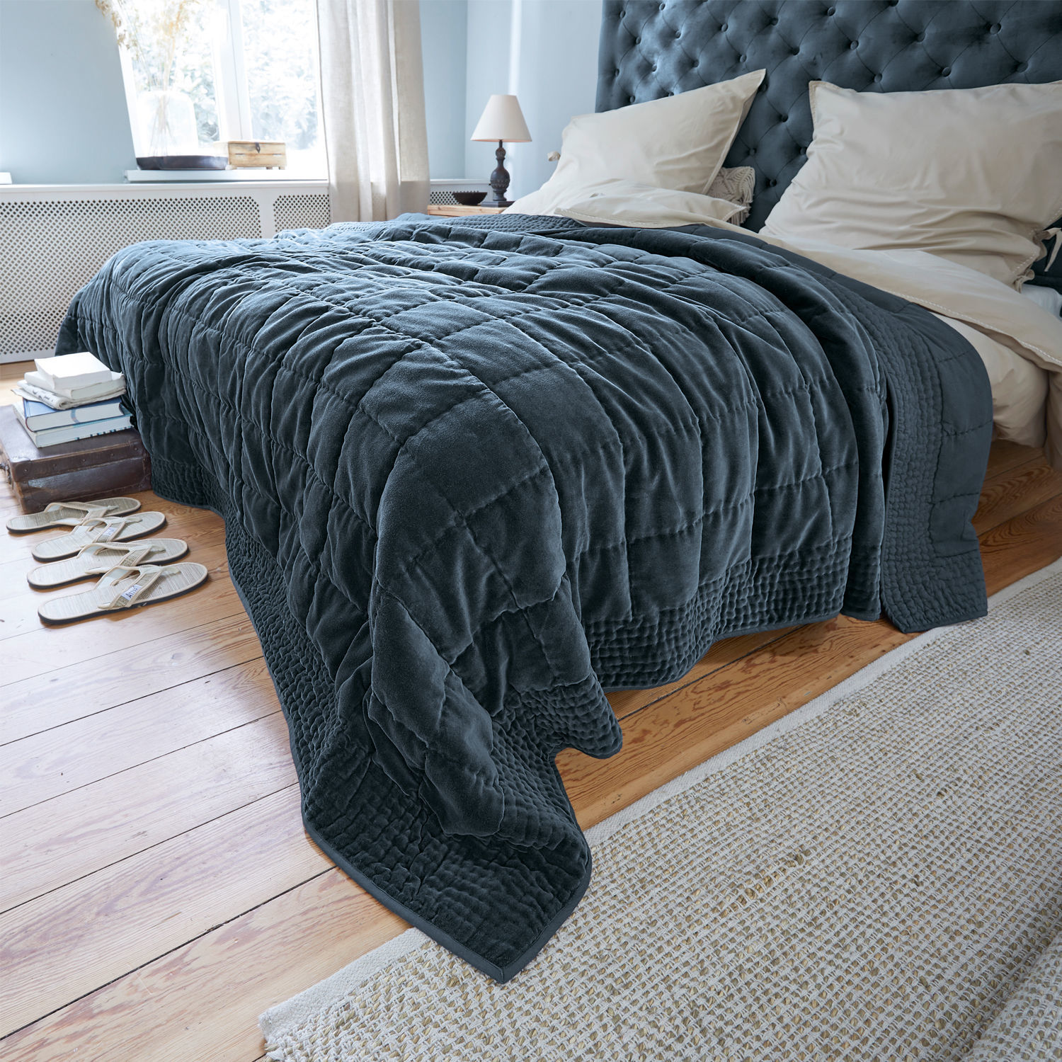 Trapunta Arasta Coperta trapuntata blu scuro in tessuto morbido su letto in camera luminosa con pavimento in legno