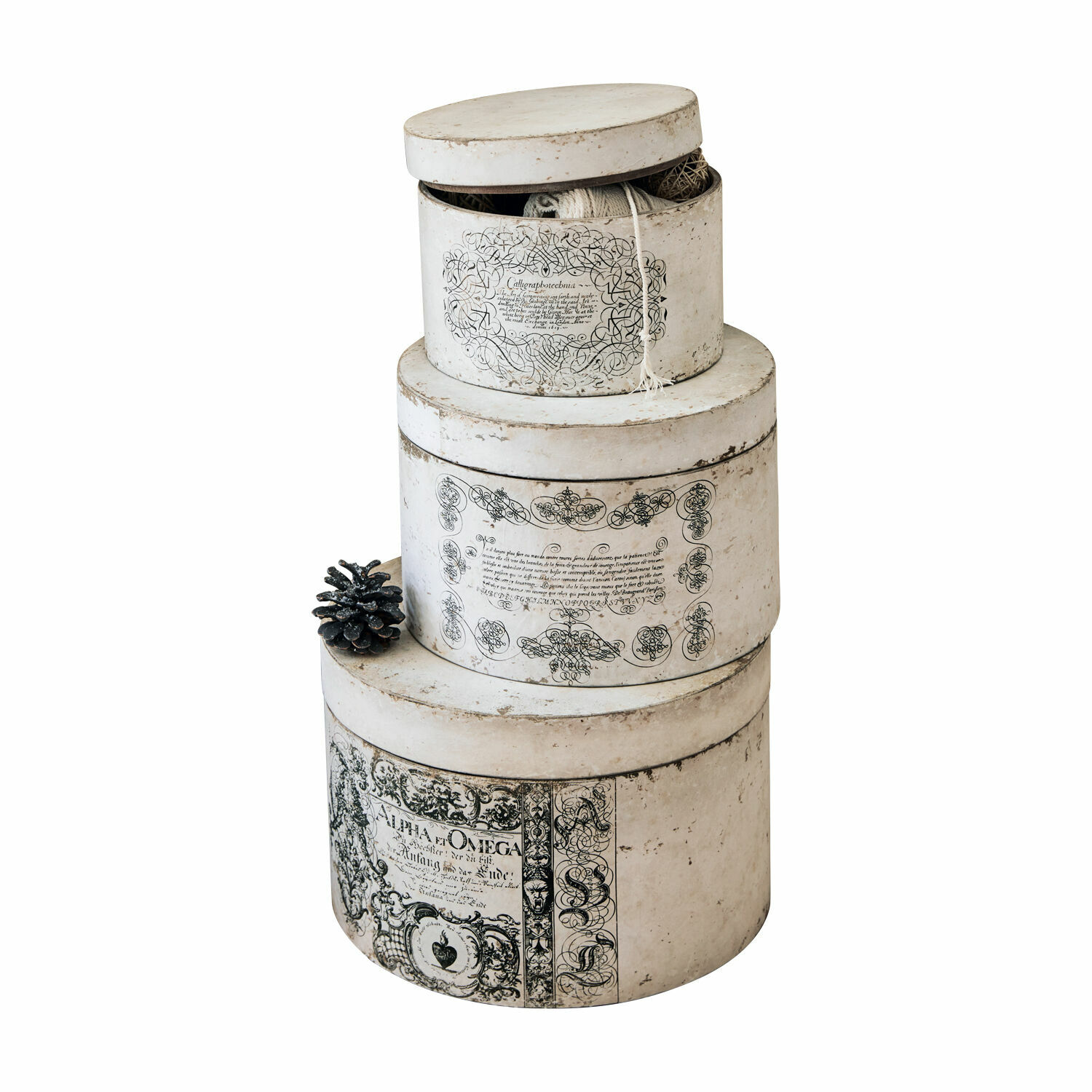 Set di 3 scatole Willma Set di tre scatole rotonde in carta color ecru con scritte decorative nere e pigna