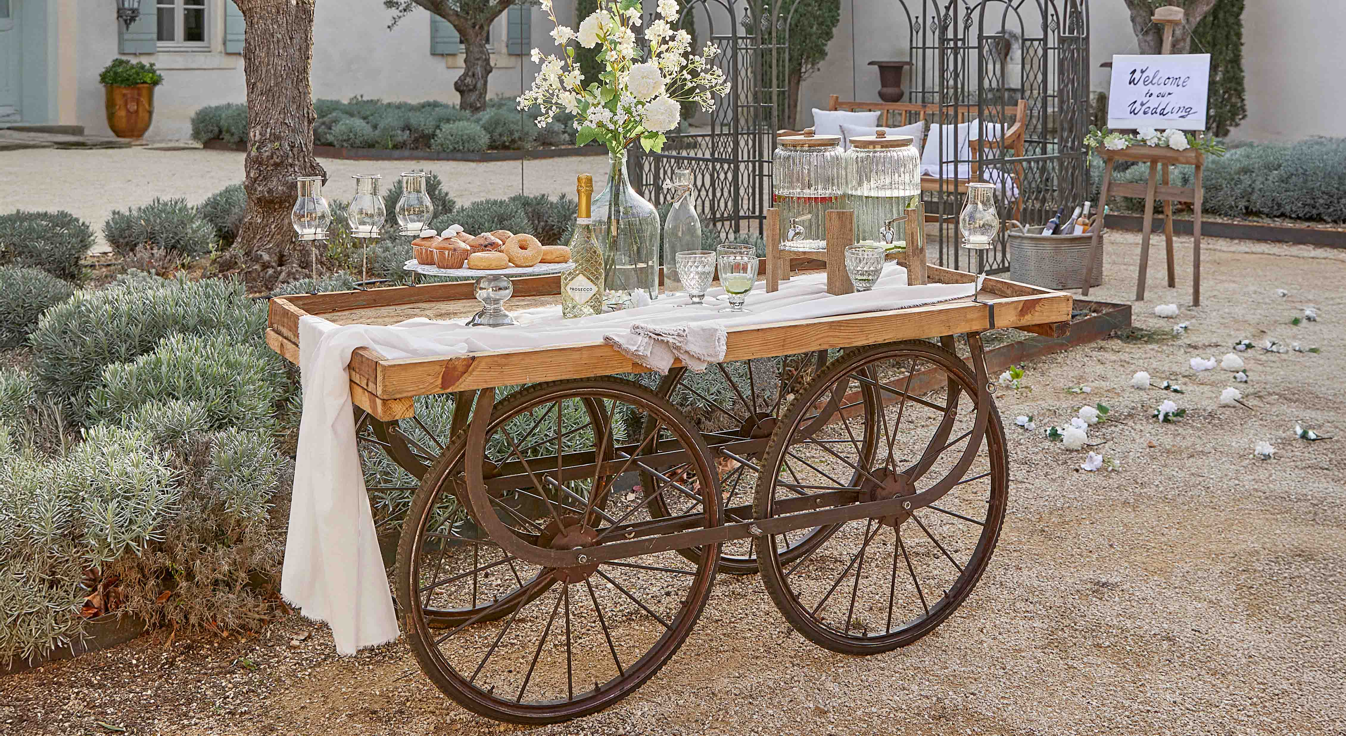 Carretto in legno con ruote in metallo decorato per matrimonio con fiori e bevande