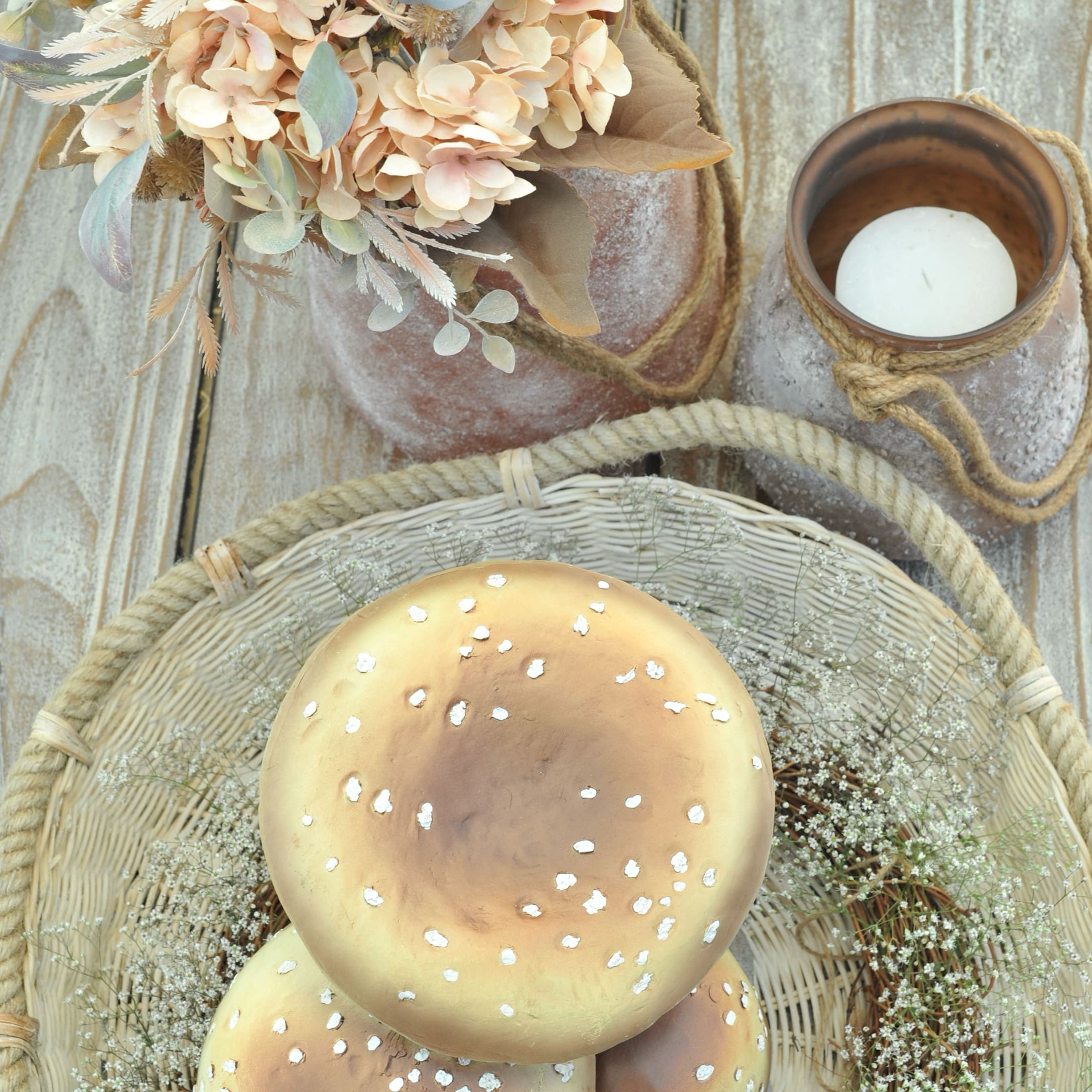 Decorazione autunnale con funghi beige in plastica, fiori e candela in stile rustico
