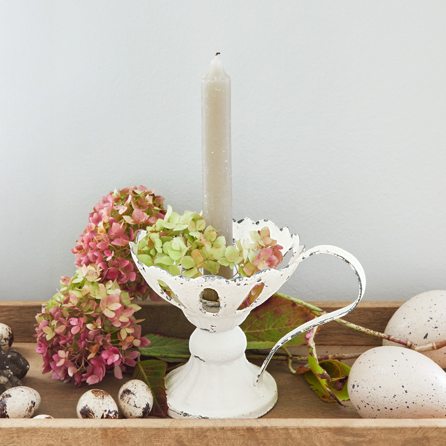Portacandele in metallo bianco con manico e candela grigia, decorato con fiori e uova decorative