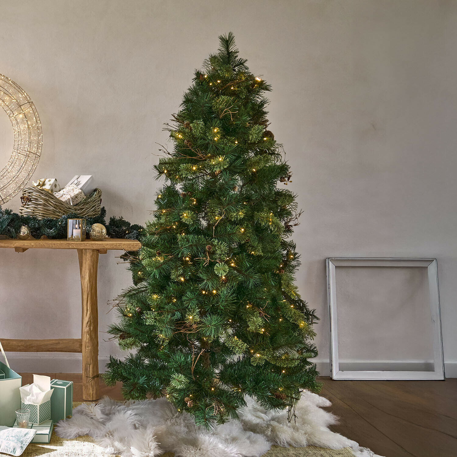 Albero di Natale Yundra Albero di Natale artificiale verde con aghi e luci LED calde su tappeto bianco in pelliccia sintetica