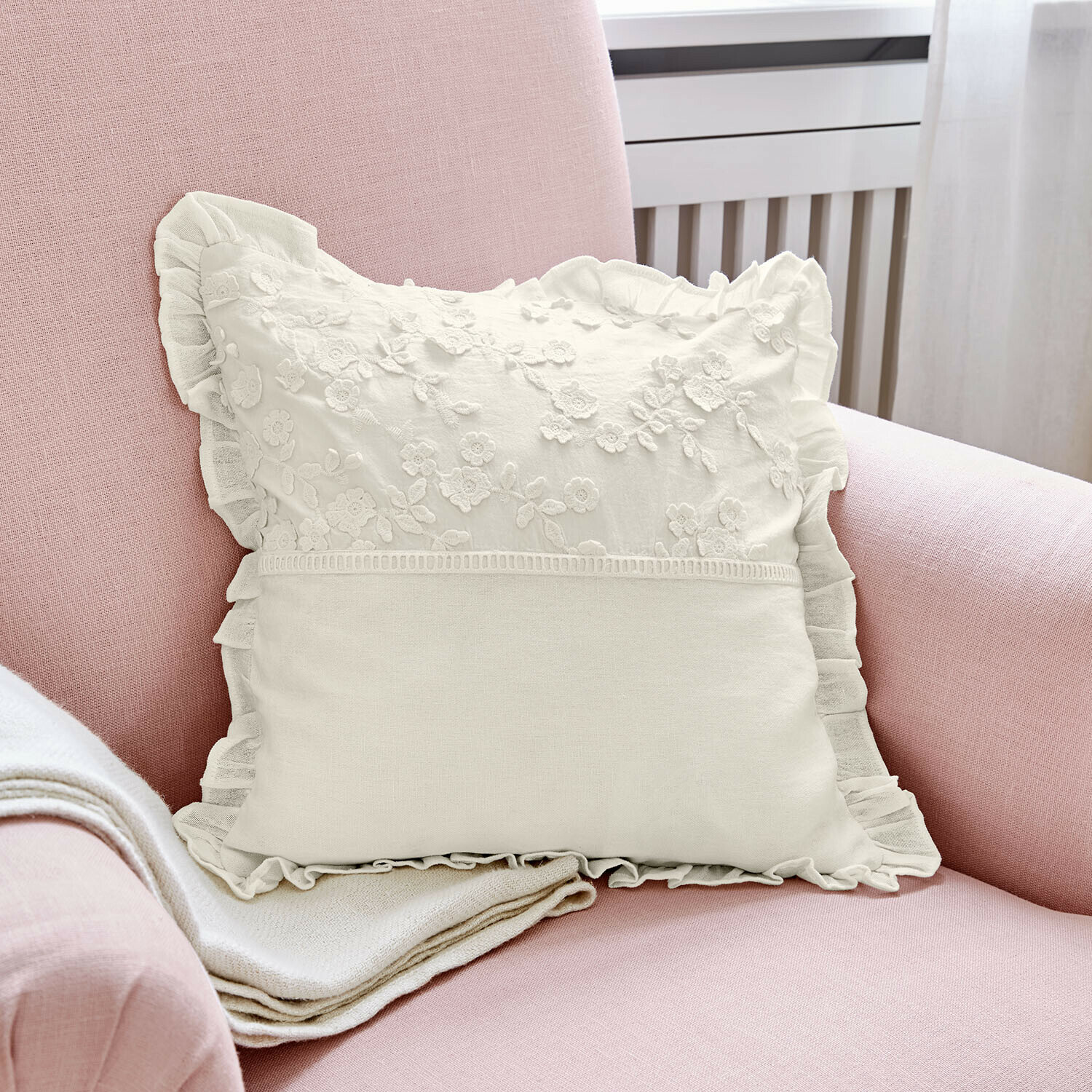 Copricuscino Lunérie Cuscino decorativo bianco con ricamo floreale e volant su poltrona rosa, tessuto morbido
