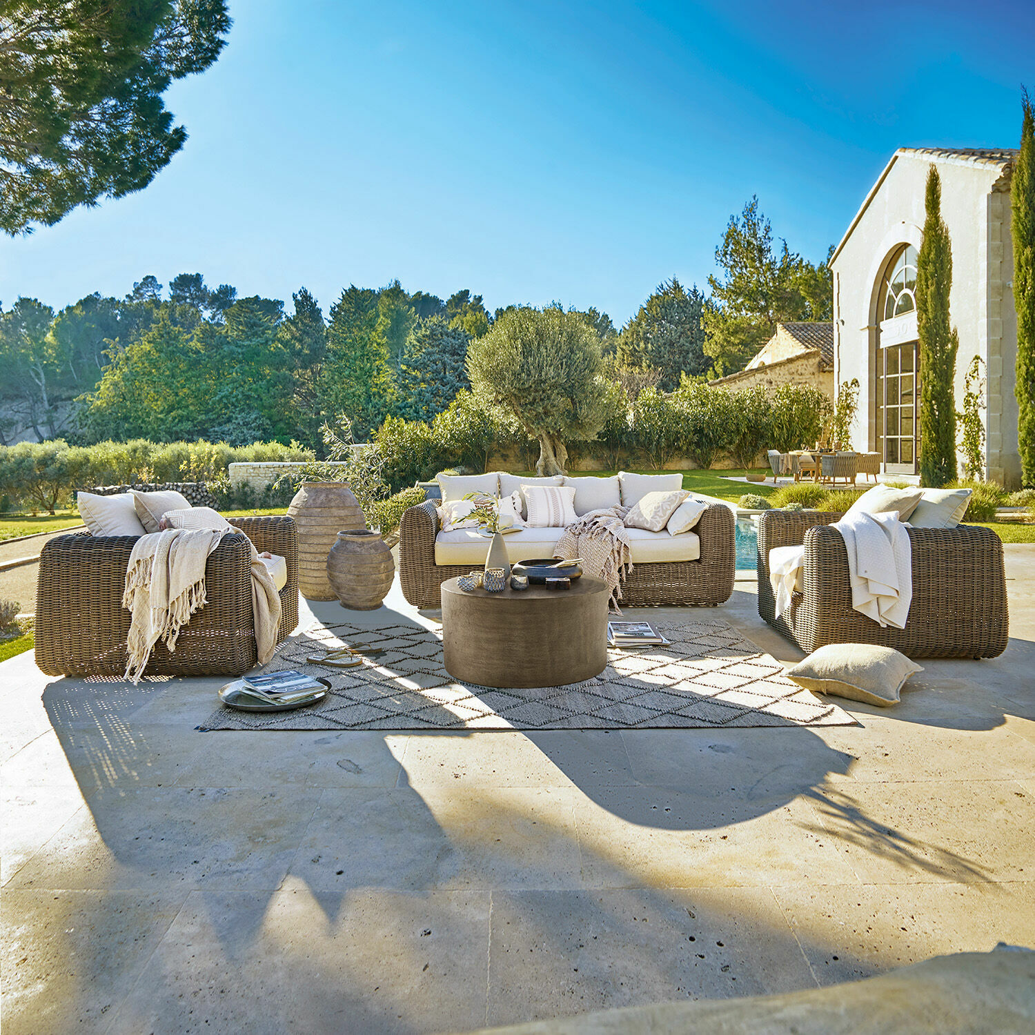 Salottino da giardino Bogdanne Set di mobili da giardino in rattan marrone con cuscini crema su terrazza con vista sul giardino
