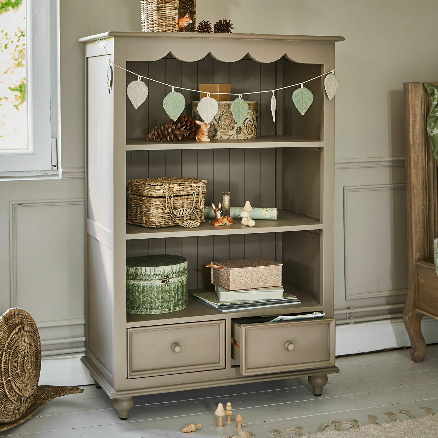 Scaffale Sorvanne Mobile beige in legno con ripiani e cassetti, decorato con oggetti naturali e cesti intrecciati
