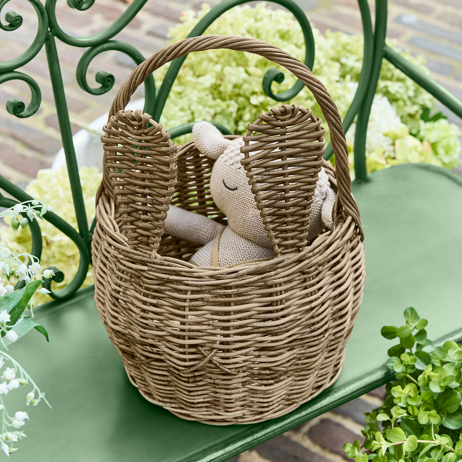 Cestino Whimsywood Cesto in vimini naturale a forma di coniglio con orecchie, su panchina verde in giardino