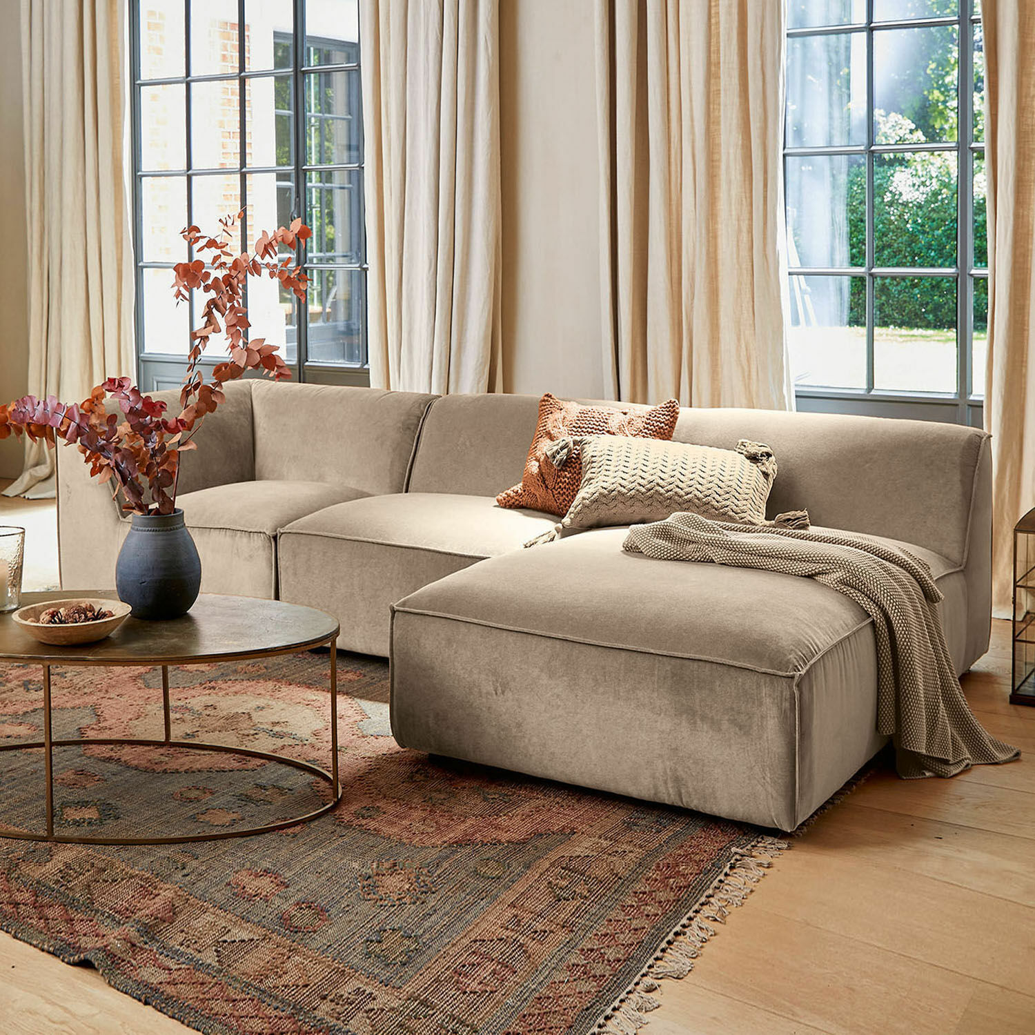 Divano McLean Divano angolare beige in tessuto morbido in soggiorno elegante con tappeto e tavolino rotondo