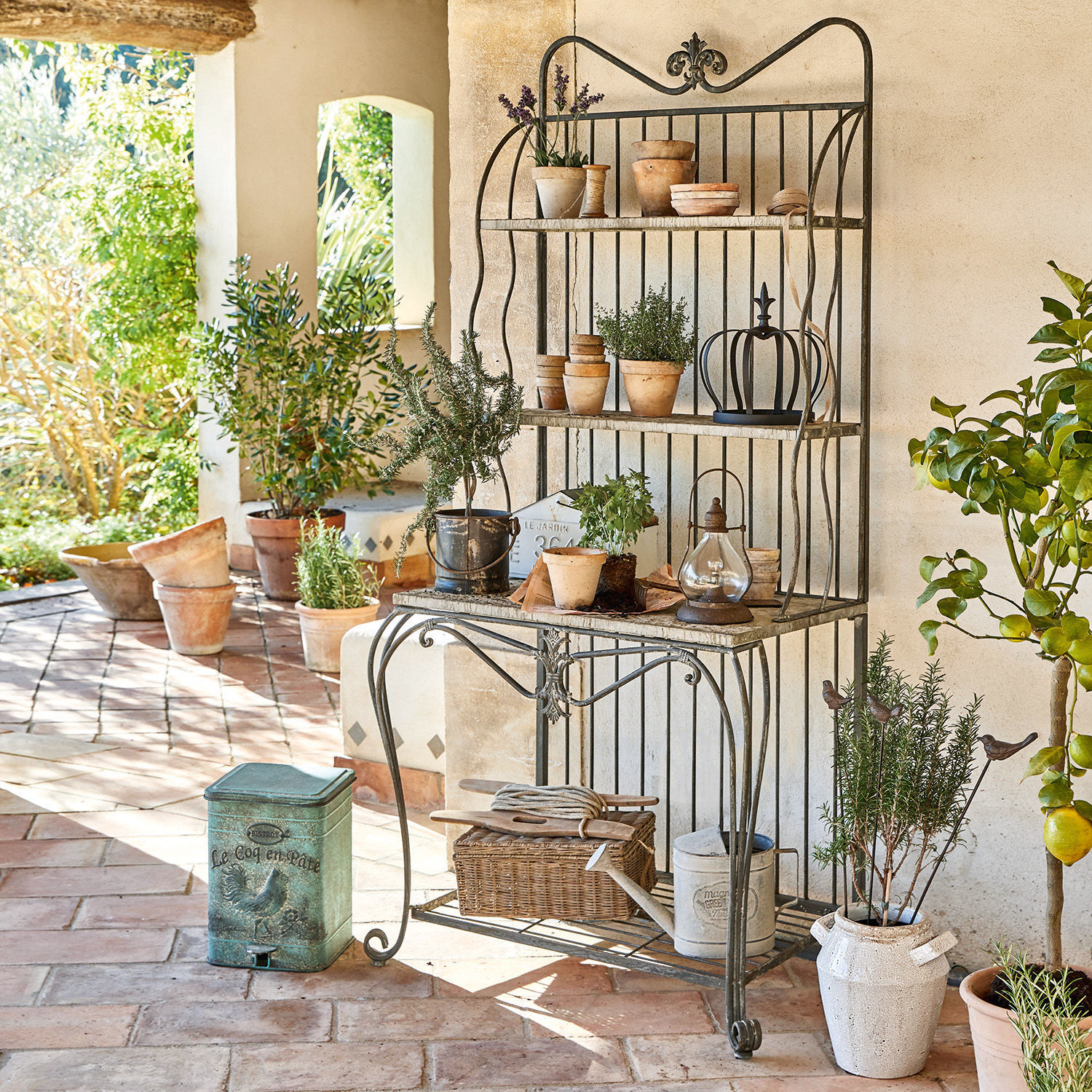 Scaffale Rentlor Mobile da giardino in metallo con ripiani e vasi in terracotta su terrazza in mattoni rustici