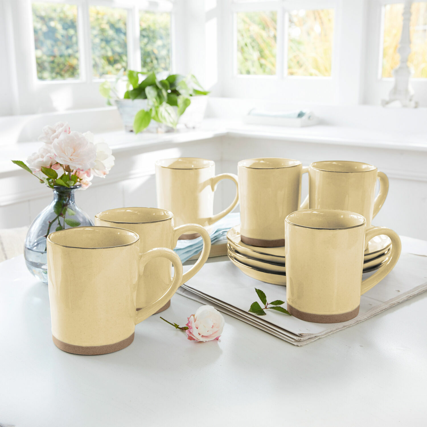 Set di 6 tazze Biarré Set di sei tazze in ceramica gialla con base marrone su tavolo chiaro in cucina luminosa