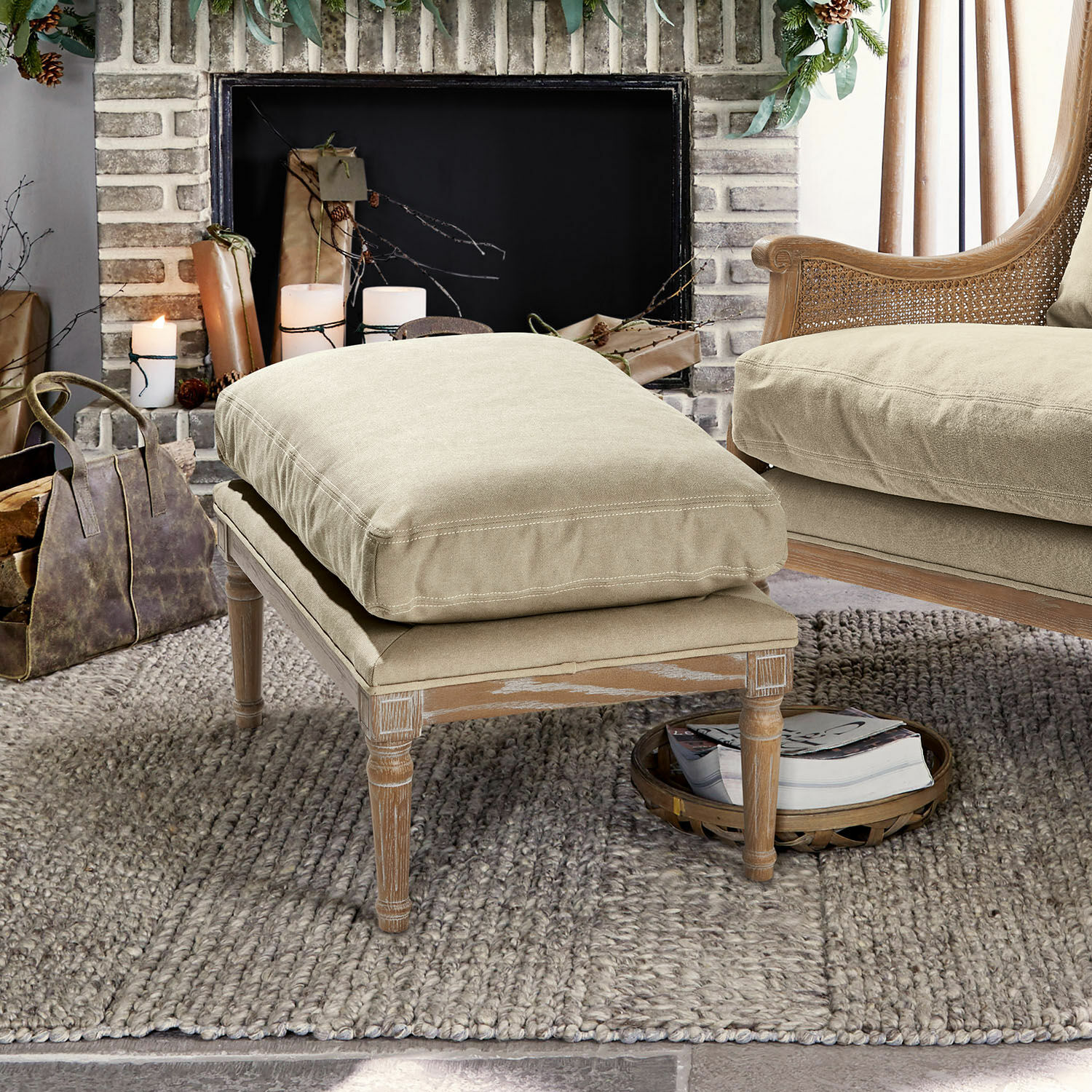 Pouf Greenbrier Poggiapiedi beige con struttura in legno e cuscino in tessuto morbido su tappeto in soggiorno accogliente