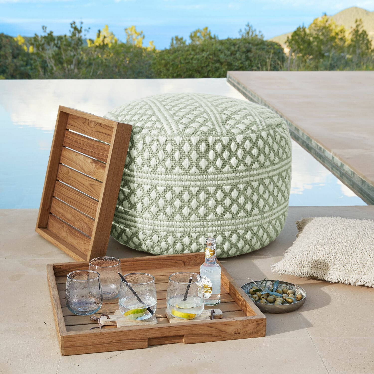 Pouf per interni ed esterni Mintares Pouf morbido verde e bianco in tessuto con motivo geometrico su terrazza vicino alla piscina