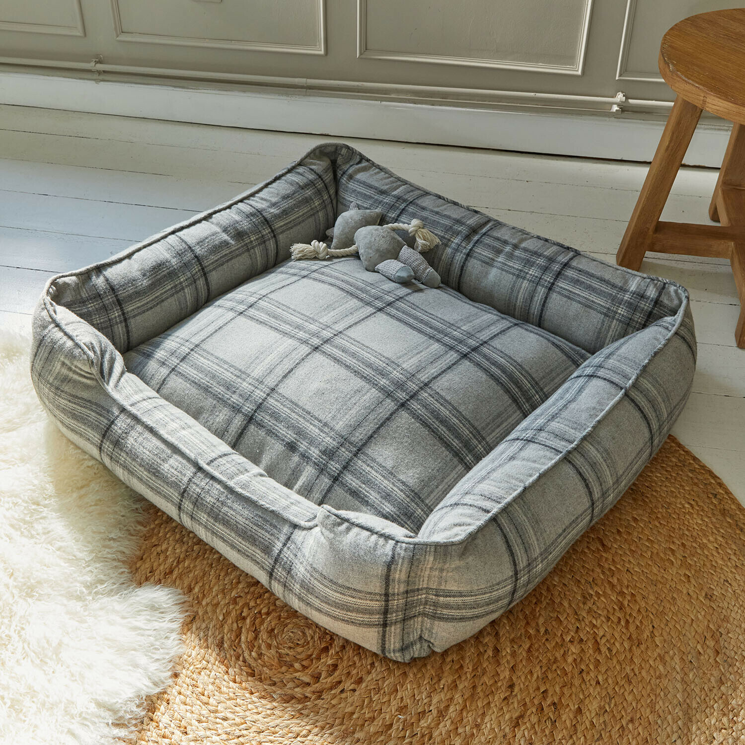 Letto per cani Creswyn Cuccia per cane grigia a quadri in tessuto morbido su tappeto intrecciato in stanza luminosa