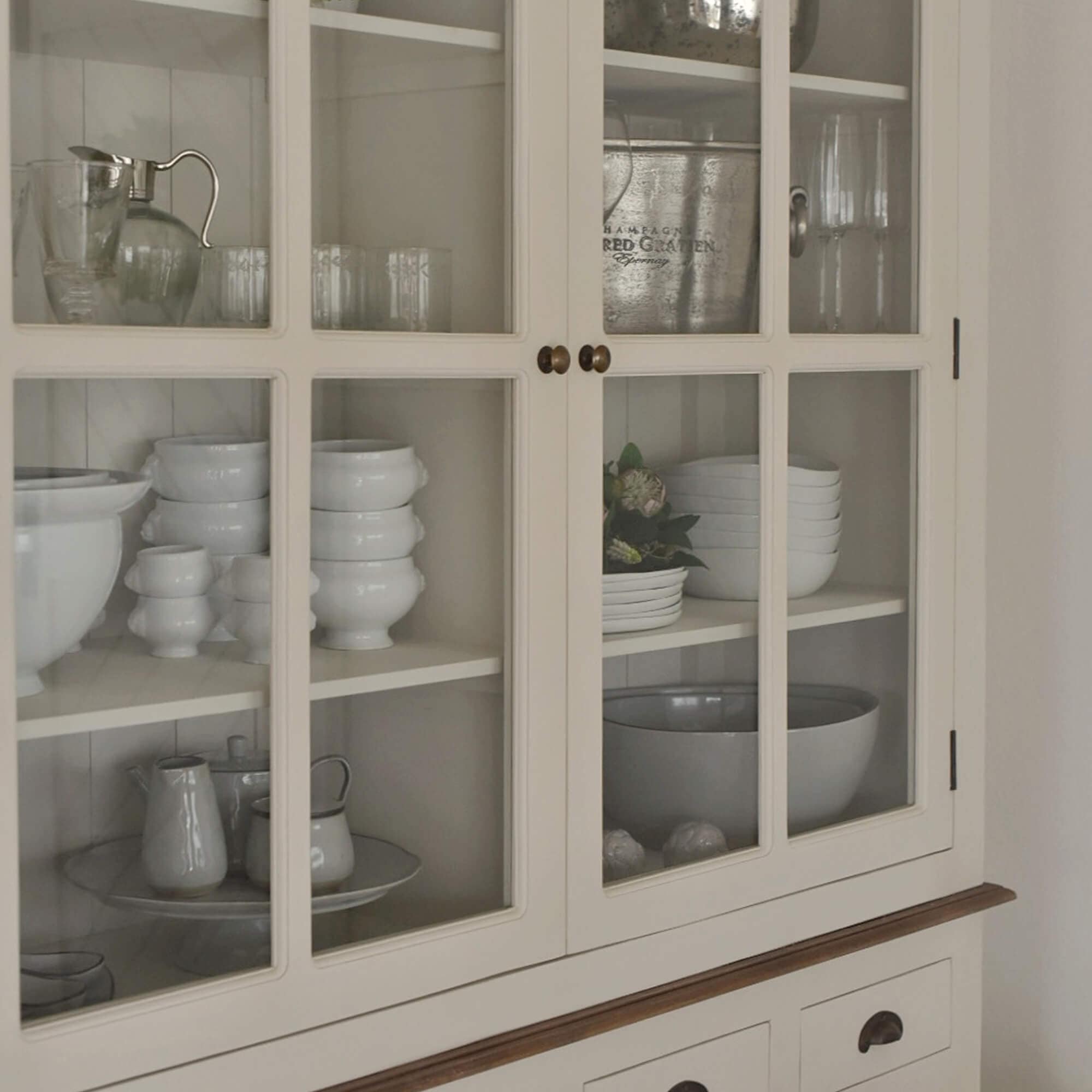 Vetrina in legno crema con ante in vetro e porcellana bianca all'interno, mobile da sala da pranzo